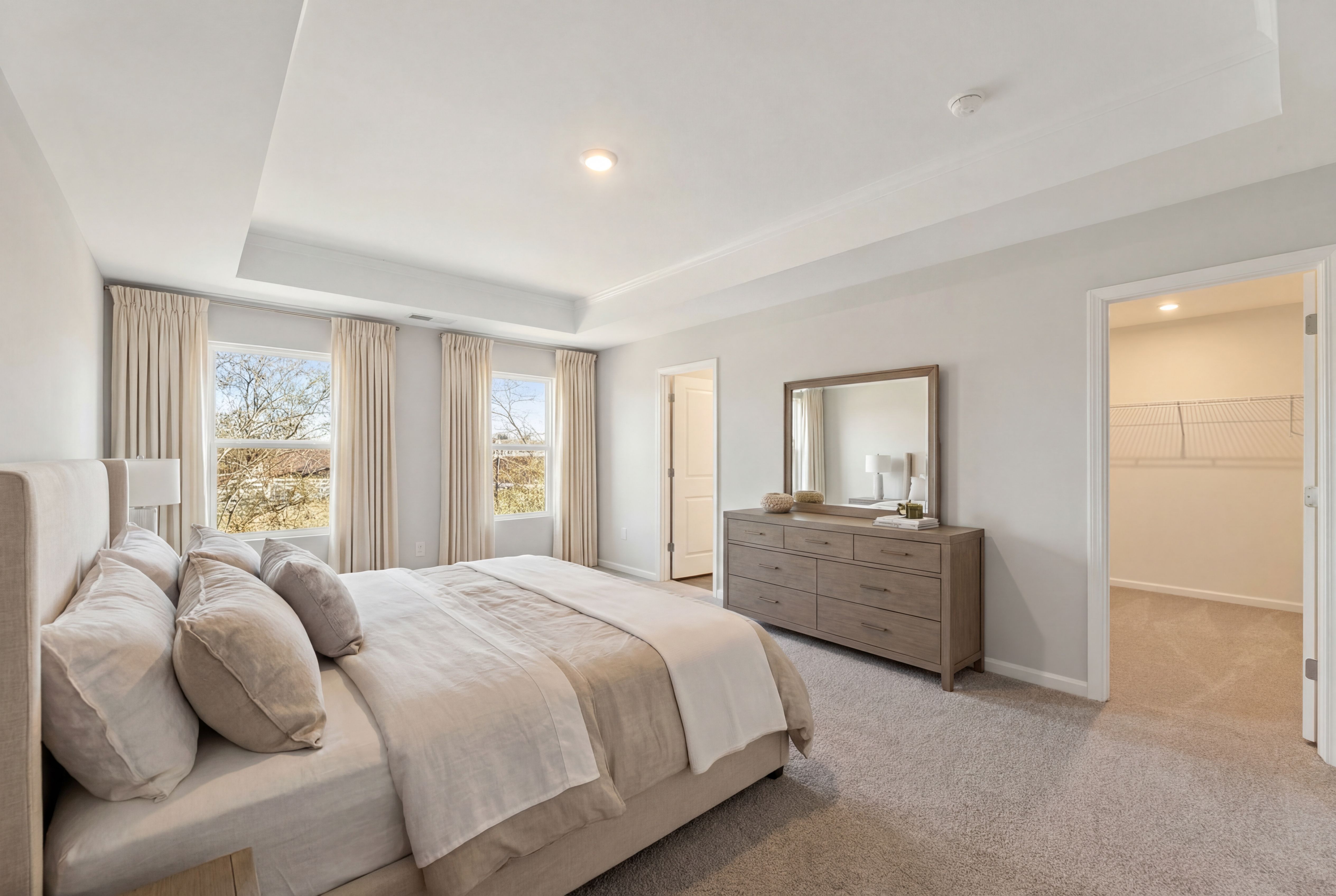 Spacious master bedroom in Lake Shore, Winder GA with king bed, neutral bedding, dresser, large windows and walk-in closet