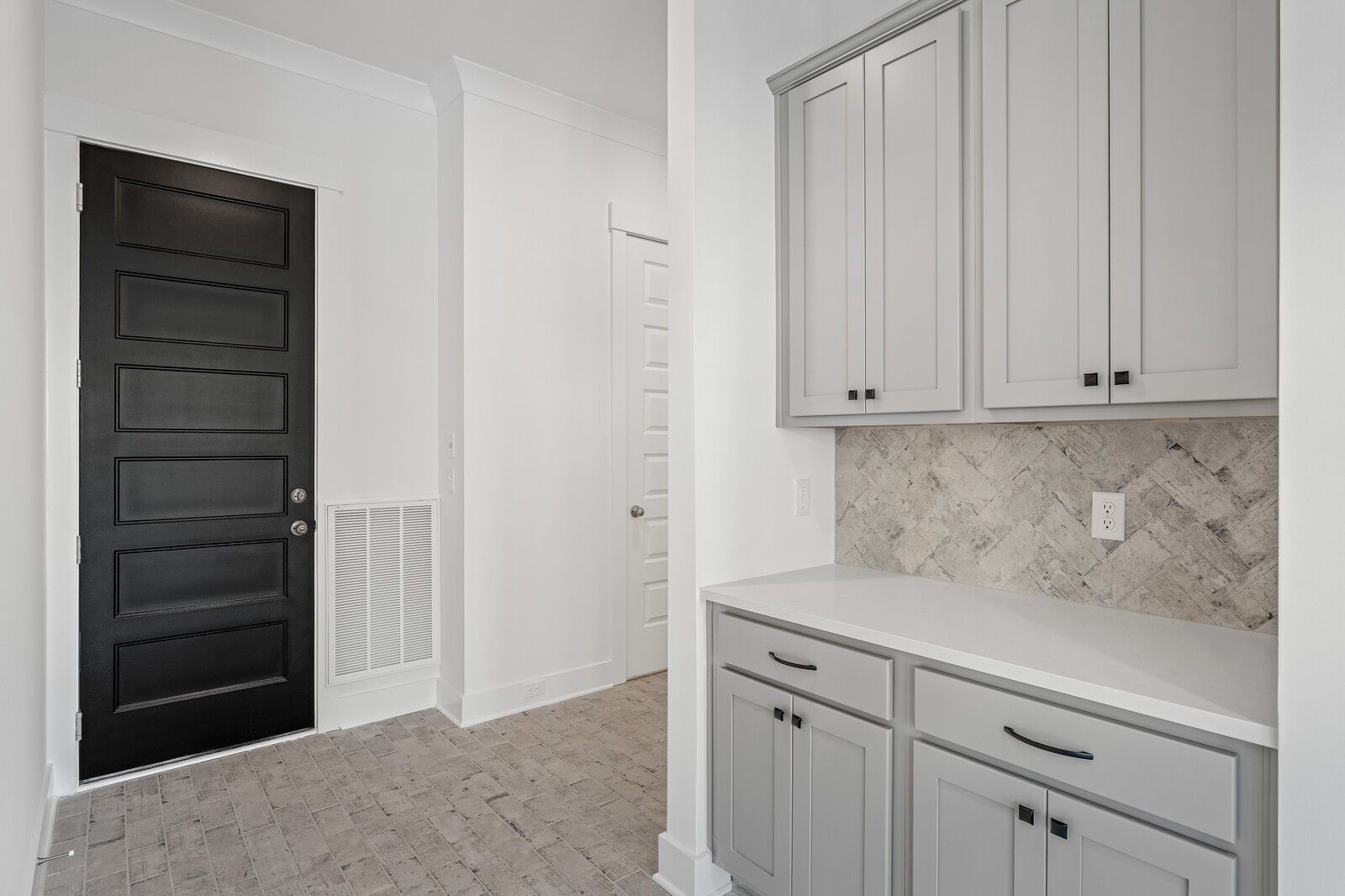 Modern mudroom with gray shaker cabinets, herringbone tile backsplash, white quartz counter in The Alston A, Shelton Square, Murfreesboro