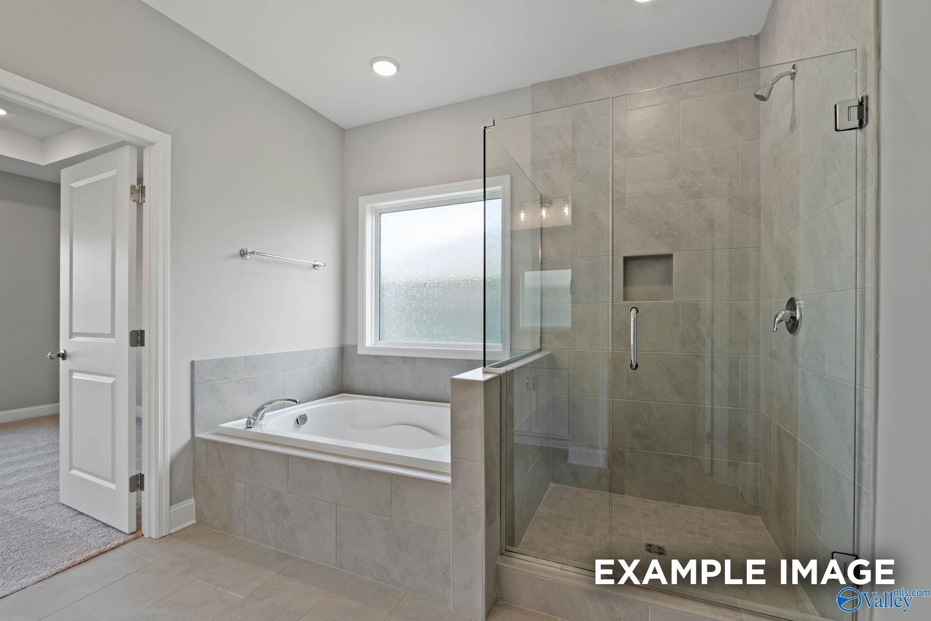 Modern master bathroom featuring freestanding tub and frameless glass shower in Davidson Homes The Montgomery B, Hartselle, Alabama