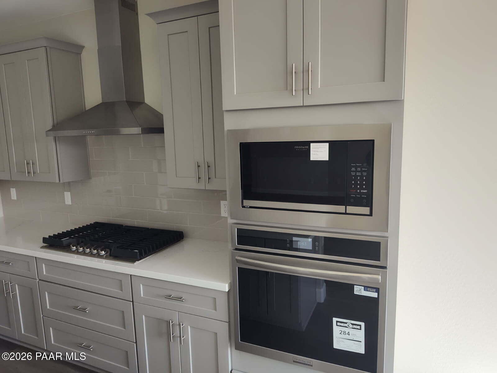 Modern kitchen featuring gray shaker cabinets, white quartz counters, stainless Frigidaire microwave and oven in The Harmony C, Prescott Valley, AZ