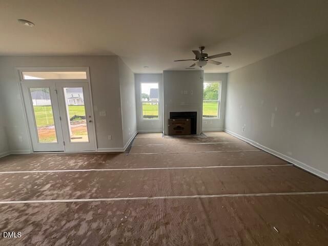 Open-concept living room with fireplace and glass patio doors in The Ash B floor plan at Retreat at North Main, Lillington.