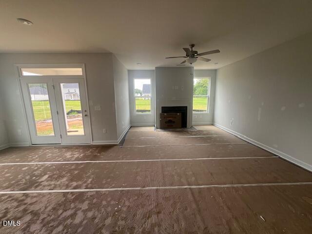 Open-concept living room with fireplace and glass patio doors in The Ash B floor plan at Retreat at North Main, Lillington.
