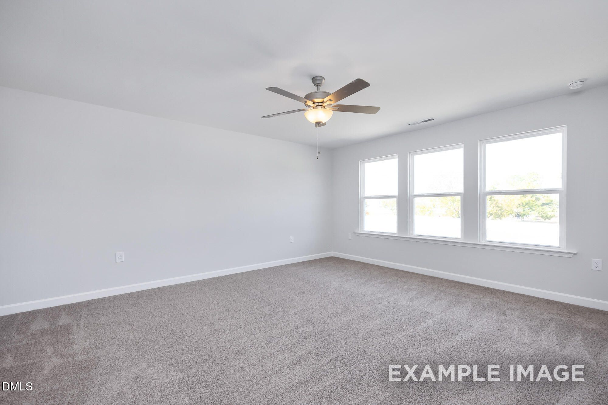 Bright secondary bedroom with gray carpet, three large windows, and ceiling fan in 5-bedroom Davidson Homes The Hickory II B, Lillington, NC