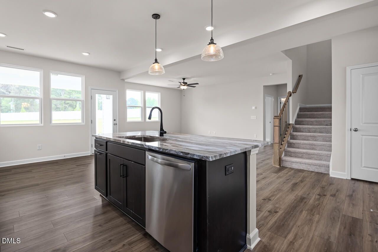 Open-concept kitchen with island and pendant lighting in The Willow B floor plan at Woodland Crossing, Zebulon, NC.