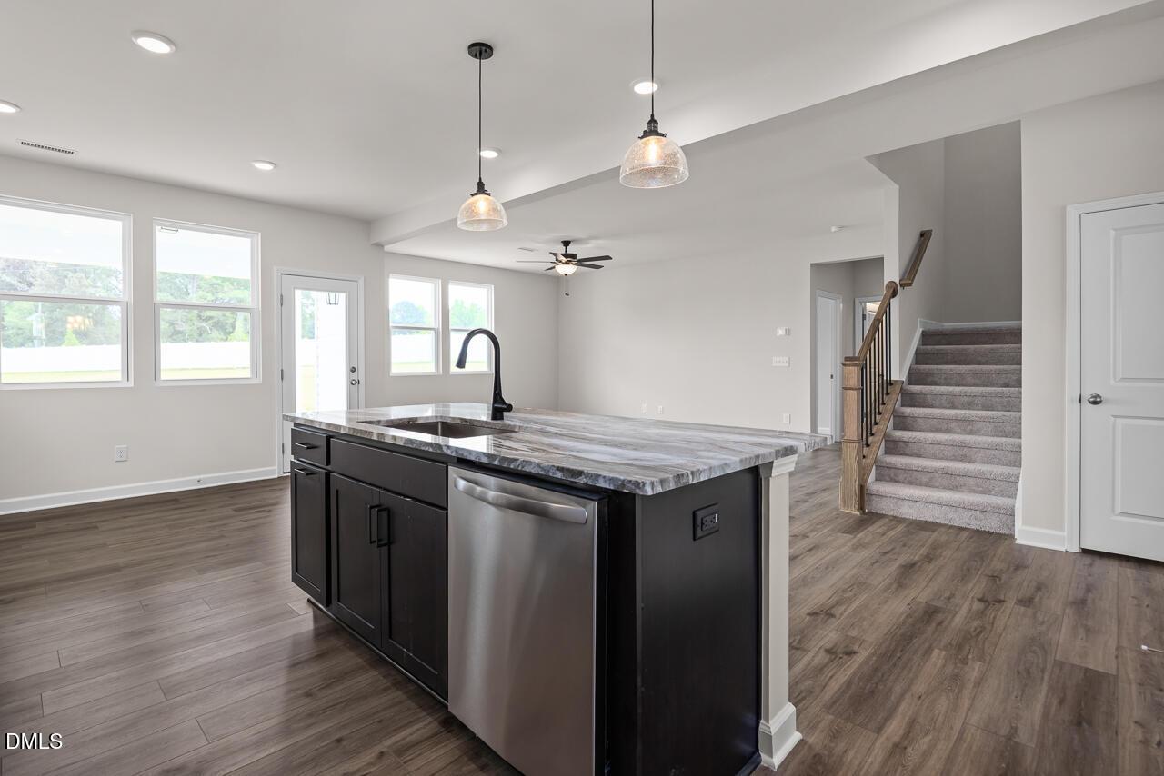 Open-concept kitchen with island and pendant lighting in The Willow B floor plan at Woodland Crossing, Zebulon, NC.