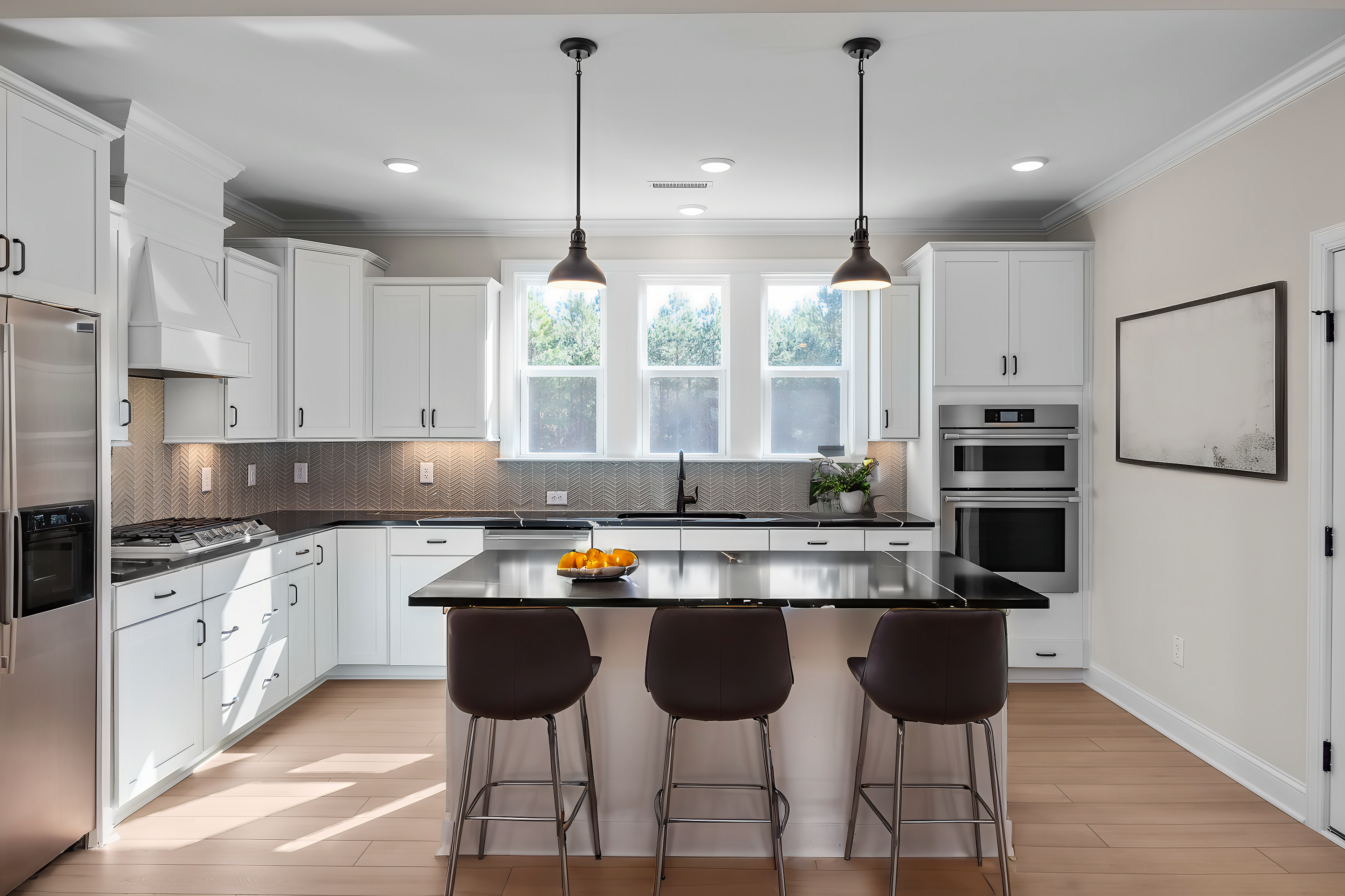 Spacious modern kitchen with white cabinets, black quartz island, stainless steel appliances at Enclave at Belmont in Belmont, NC