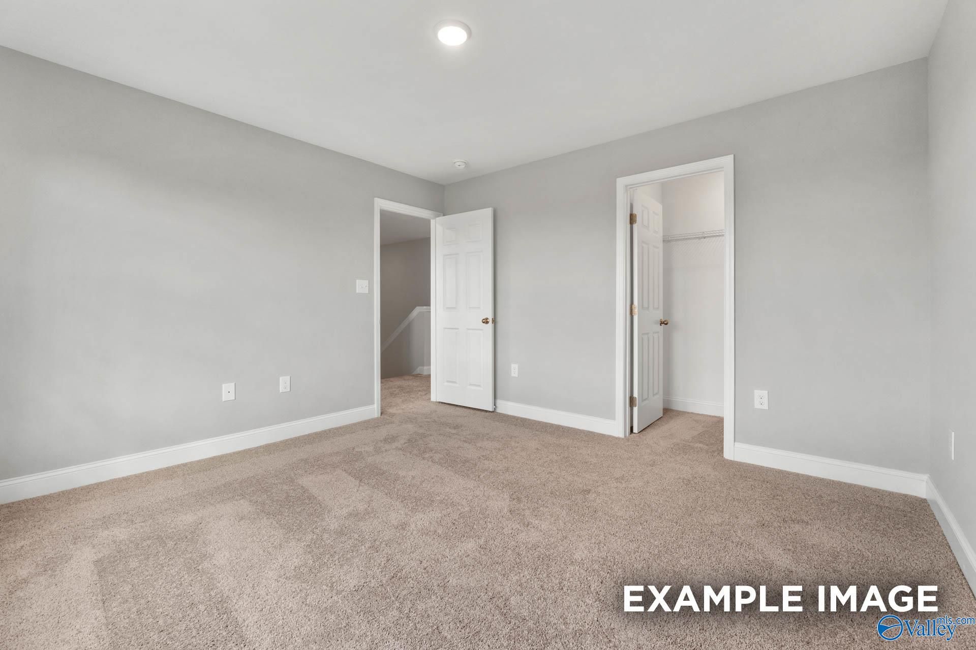 Spacious empty bedroom with gray walls, beige carpet, closet doors in Davidson Homes Shelby B, Ricketts Farm, Athens AL