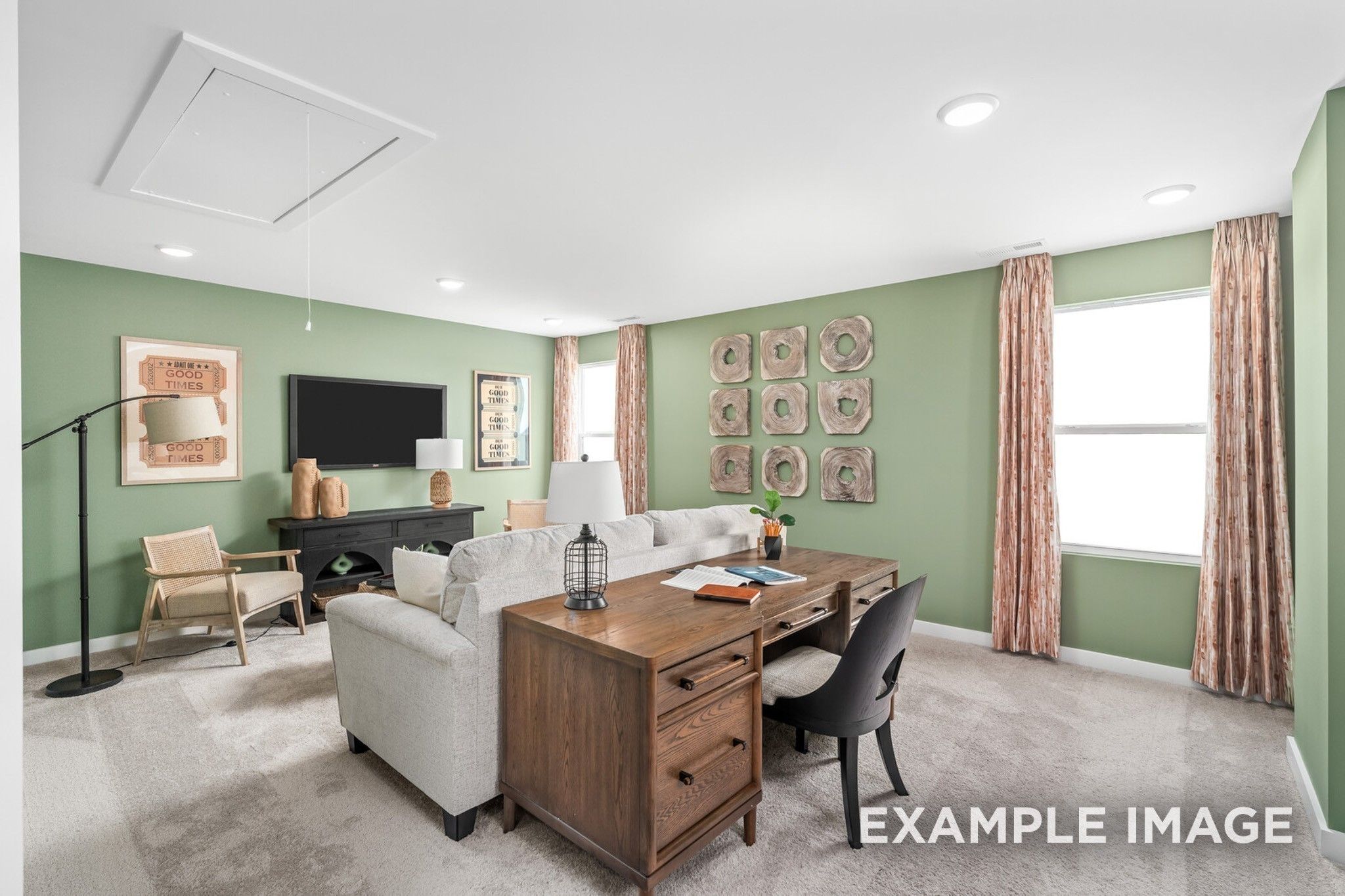 Cozy home office with wooden desk, mounted TV, green walls and plush seating in Davidson Homes The Ash A, Gallatin, TN