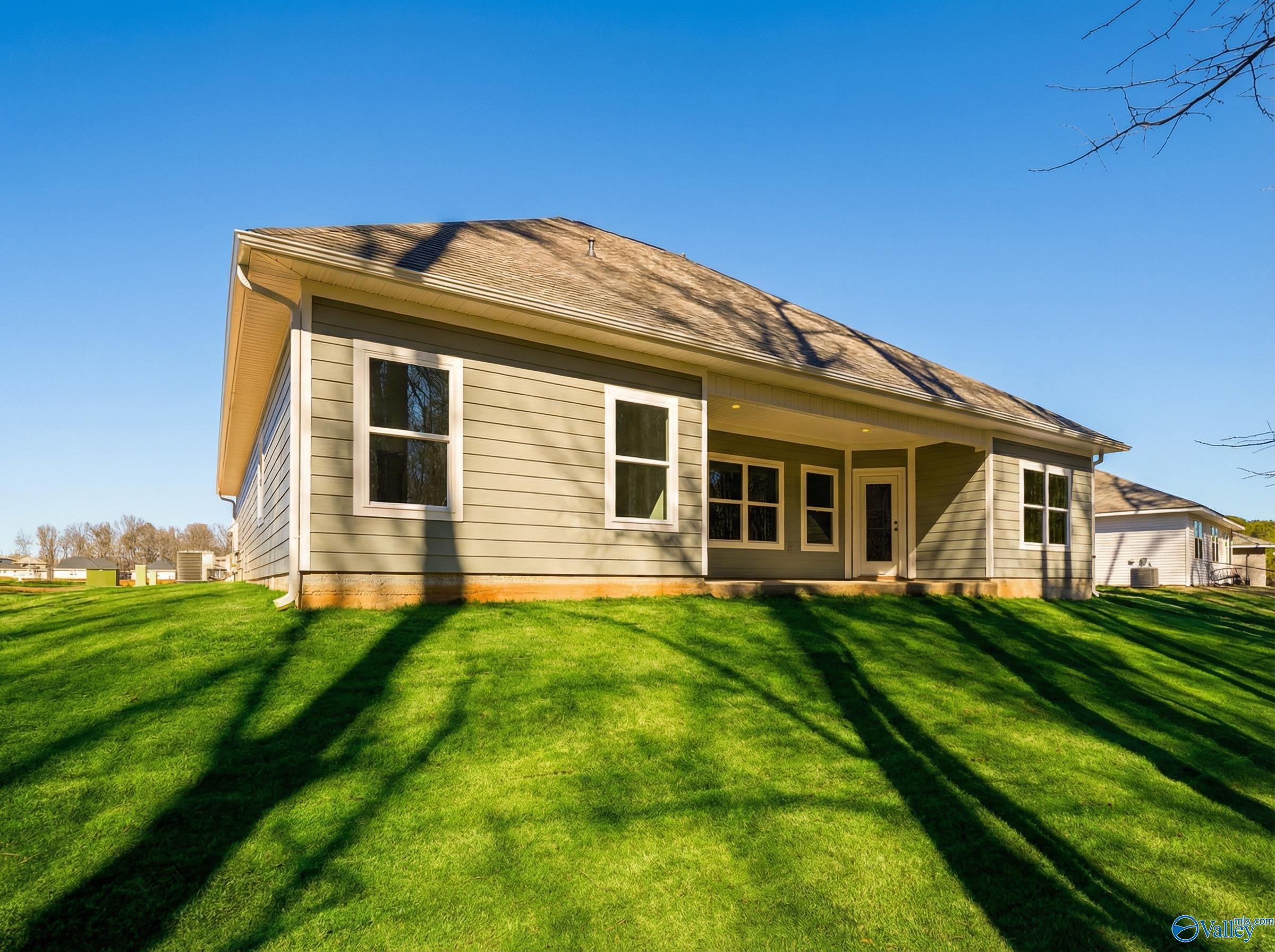 Single-story Rockford D home by Davidson Homes with beige siding, covered porch, and green lawn in Forest Glen, Hazel Green, Alabama