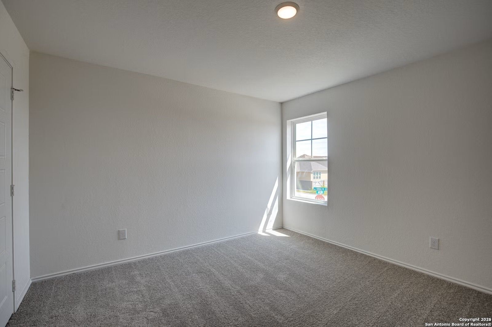 Bright secondary bedroom with carpeted floor, neutral walls, and sunlit window in Davidson Homes The Douglas B, Seguin, Texas