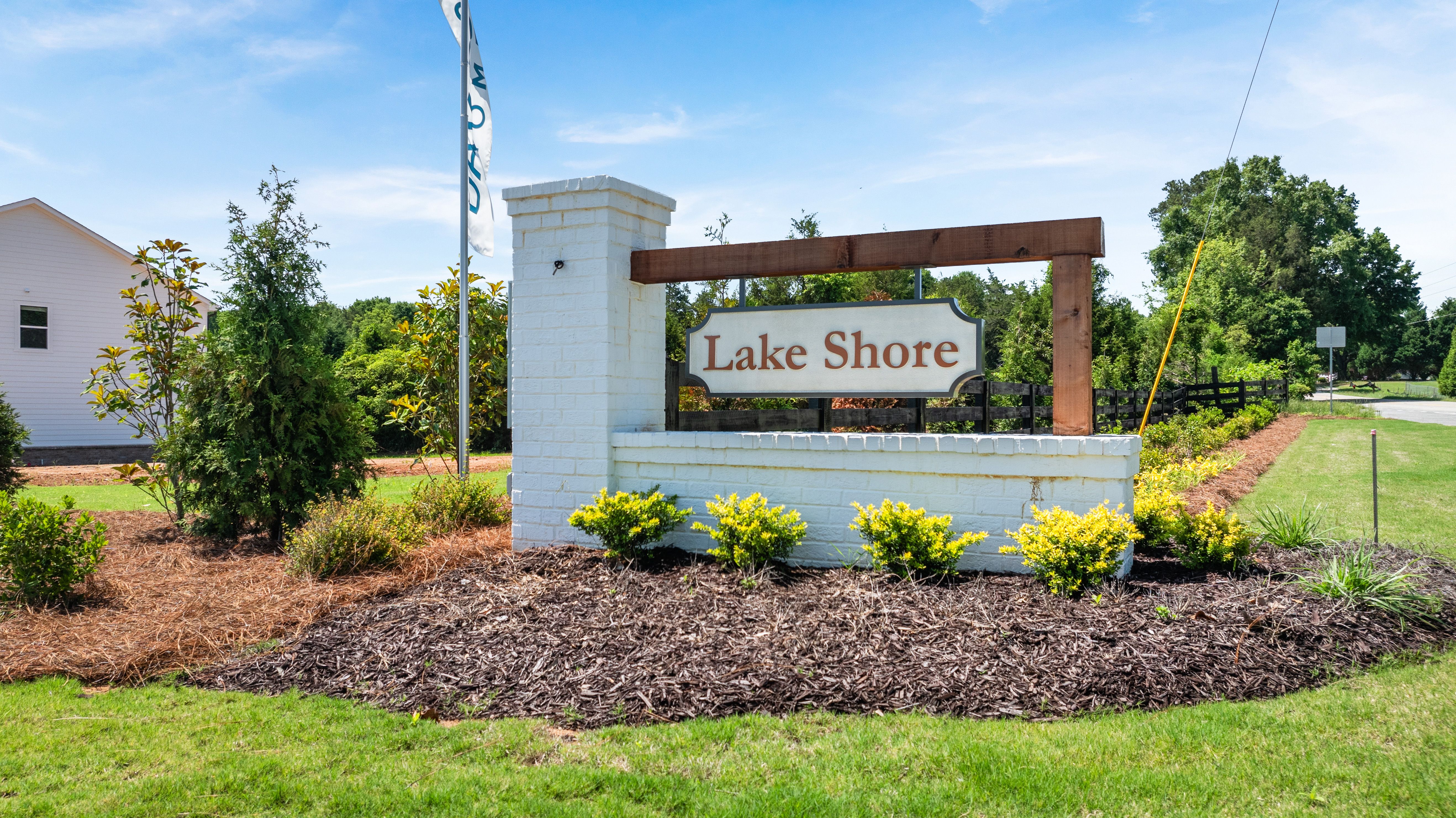 Lake Shore community entrance sign with white brick pillar and landscaping at a Davidson Homes neighborhood in Atlanta.