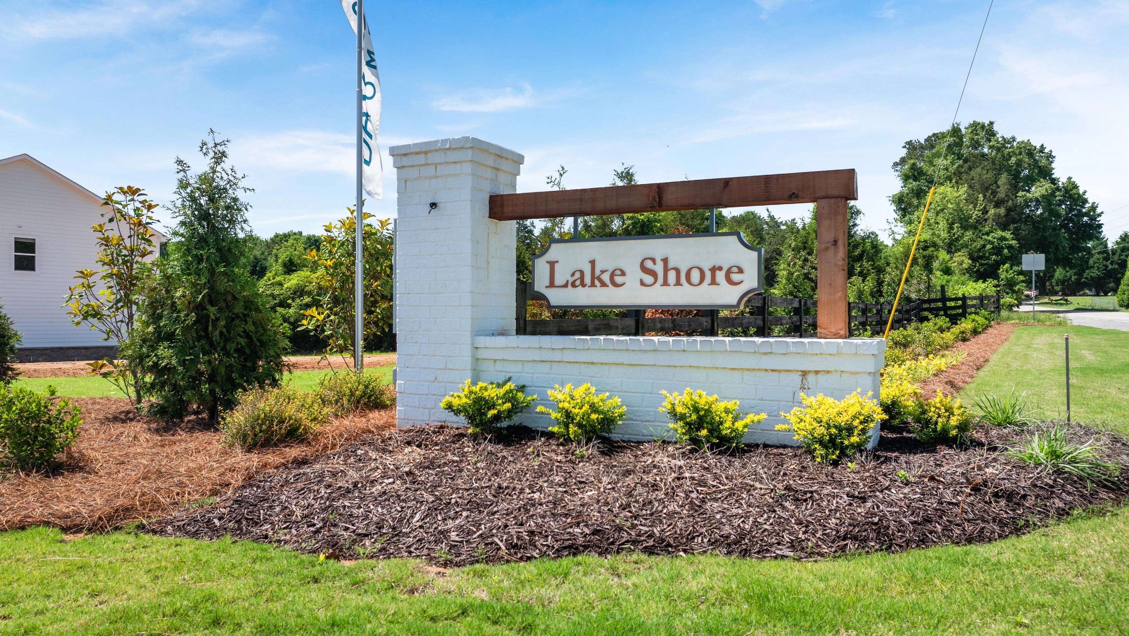 Lake Shore community entrance sign with white brick pillar and landscaping at a Davidson Homes neighborhood in Atlanta.