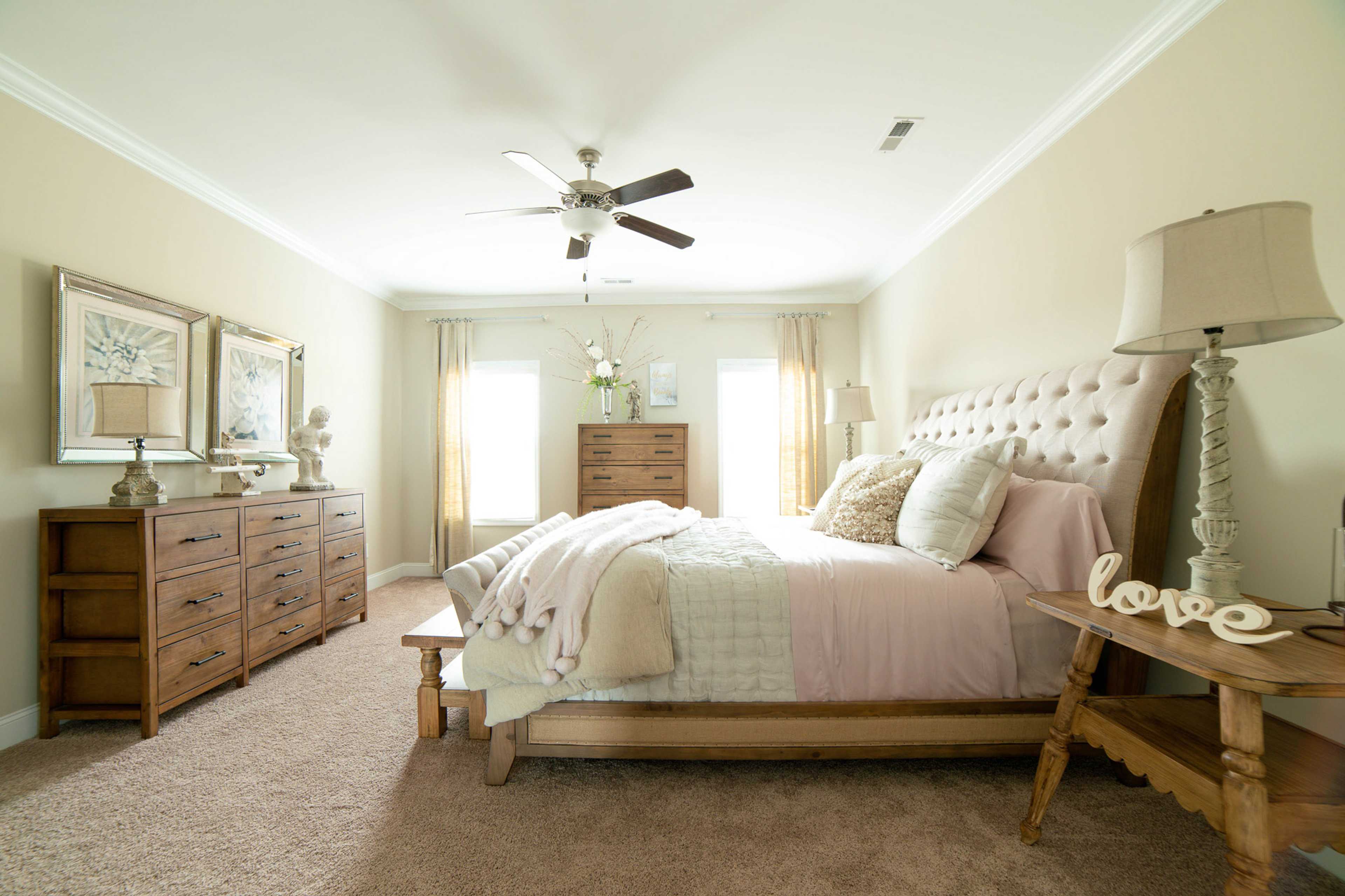 Elegant primary bedroom at The Dairy at Oak Grove in South Huntsville AL with king bed, pink bedding, wooden dresser