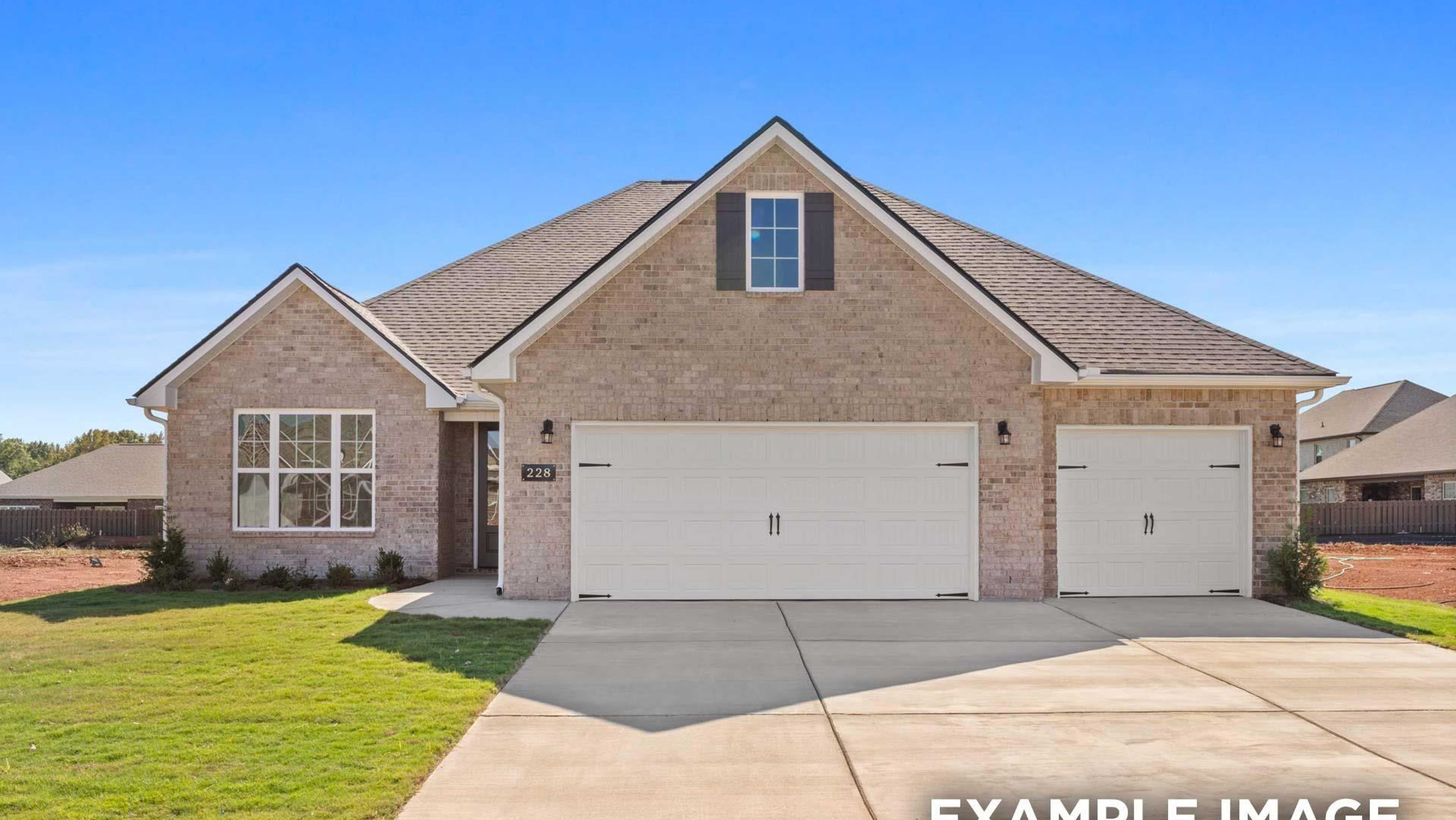Brick new home at 29159 Crawfish Drive: beige brick exterior, gabled roof, double garage, driveway, green lawn, blue sky – Davidson Homes open house