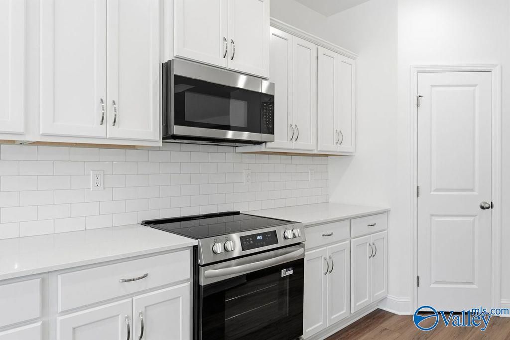 Modern kitchen featuring white shaker cabinets, stainless steel range and microwave, subway tile backsplash in Davidson Homes The Montgomery, Hartselle, AL