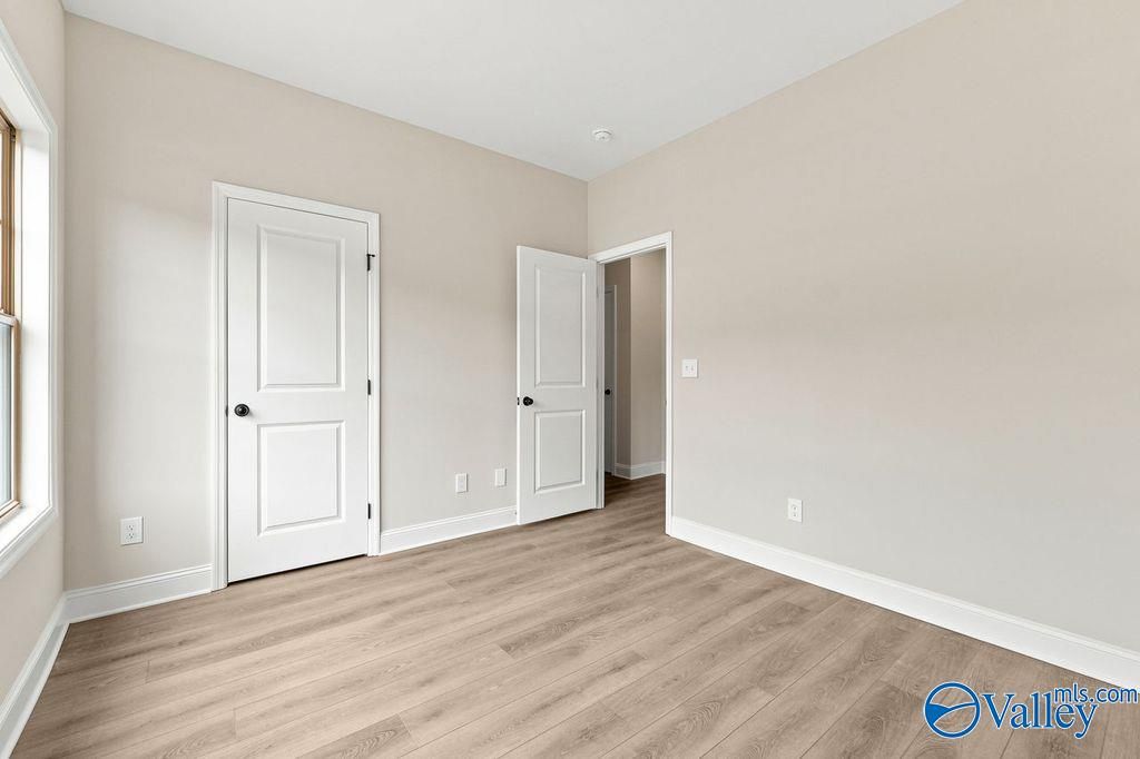 Bright, neutral-toned secondary bedroom with luxury vinyl plank flooring in The Camilla C home at The Retreat at Cain Park.