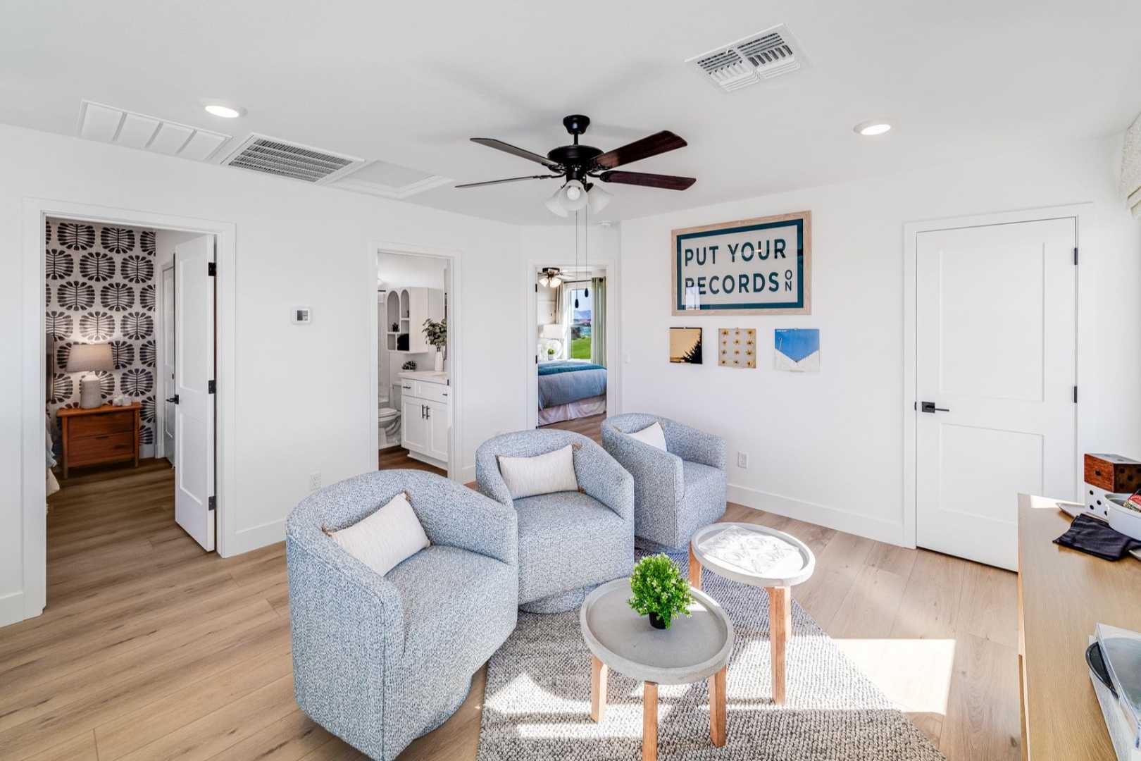 Cozy upstairs loft in The Wilmington home design with blue armchairs, plant table, desk, and open bedroom access
