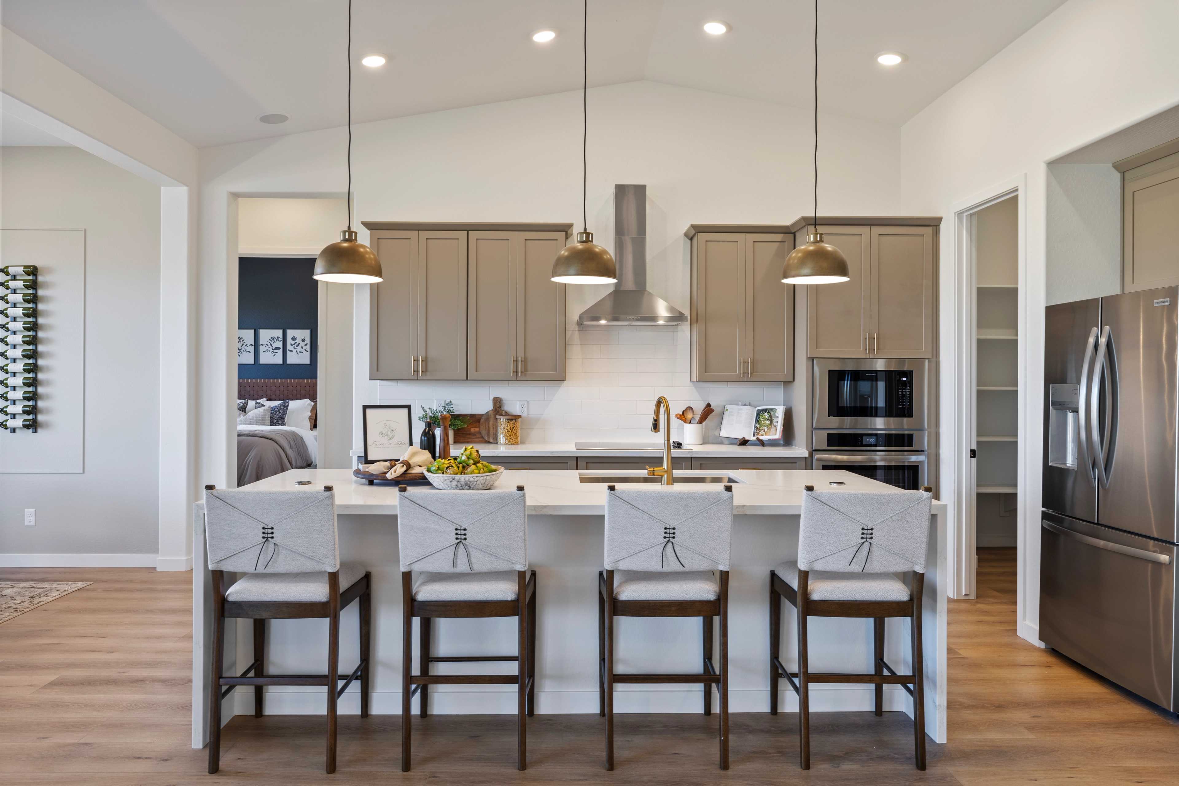 Spacious modern kitchen in Hidden Hills Prescott AZ by Davidson Homes with quartz island, bar stools, and stainless appliances
