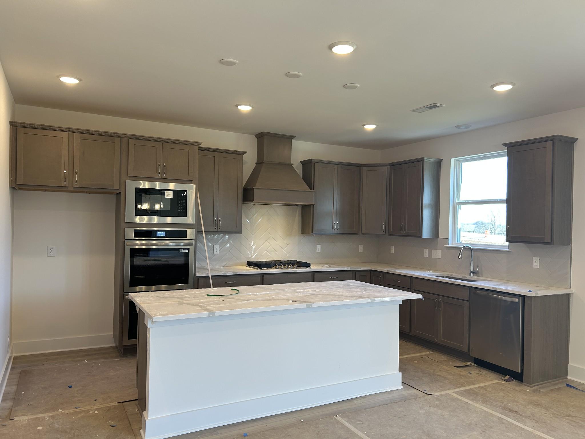 Modern shaker-style kitchen with white quartz island, stainless appliances in Davidson Homes The Henry C, Mt. Juliet, TN