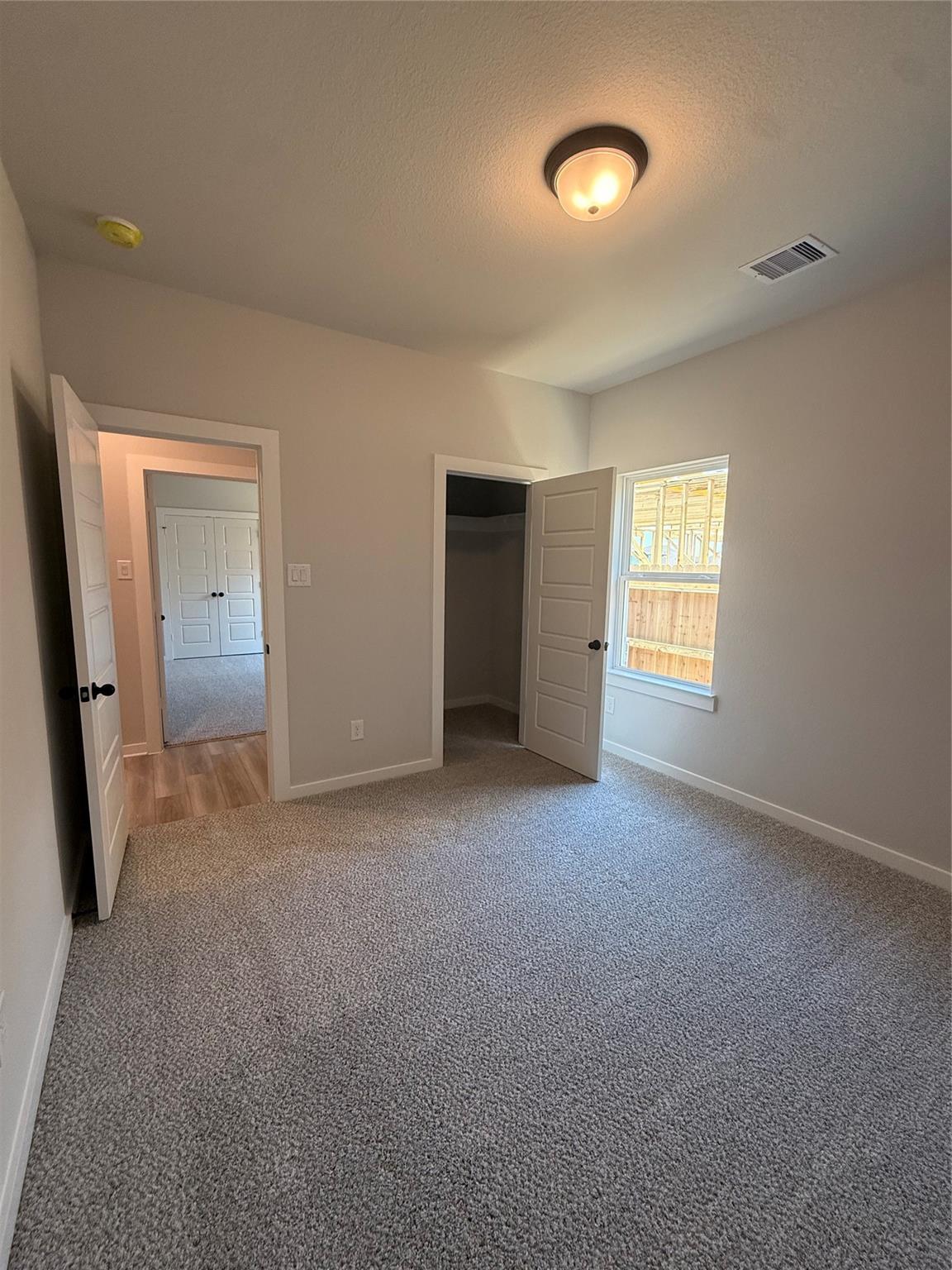Bright bedroom with walk-in closet in The Sorrento E floor plan by Davidson Homes at Sundance Cove in Crosby, Texas.
