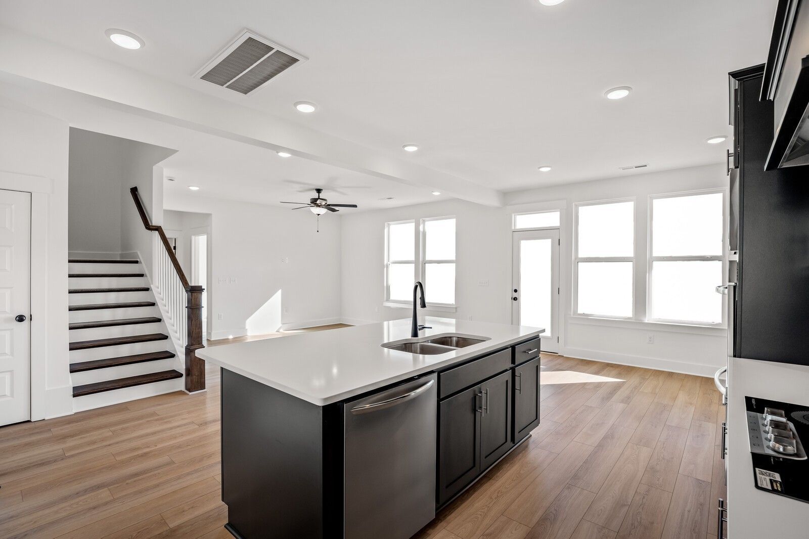 Modern open kitchen with black island, quartz counters, stainless sink in The Willow C by Davidson Homes, Gallatin, TN