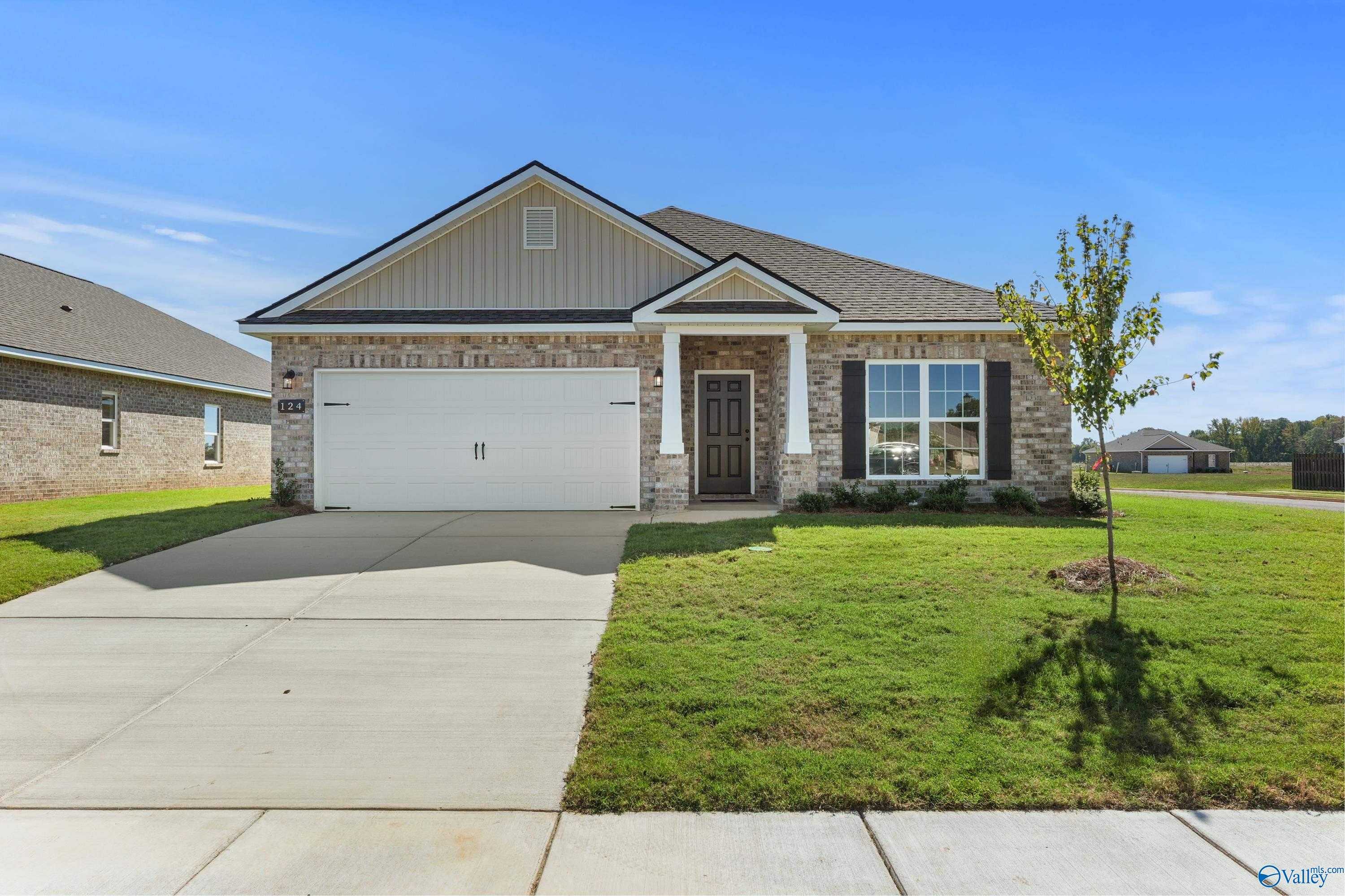 Modern 4-bedroom ranch home with brick accents, 2-car garage, driveway, and lush lawn in Clearview, Hazel Green, Alabama - Davidson Homes The Daphne C