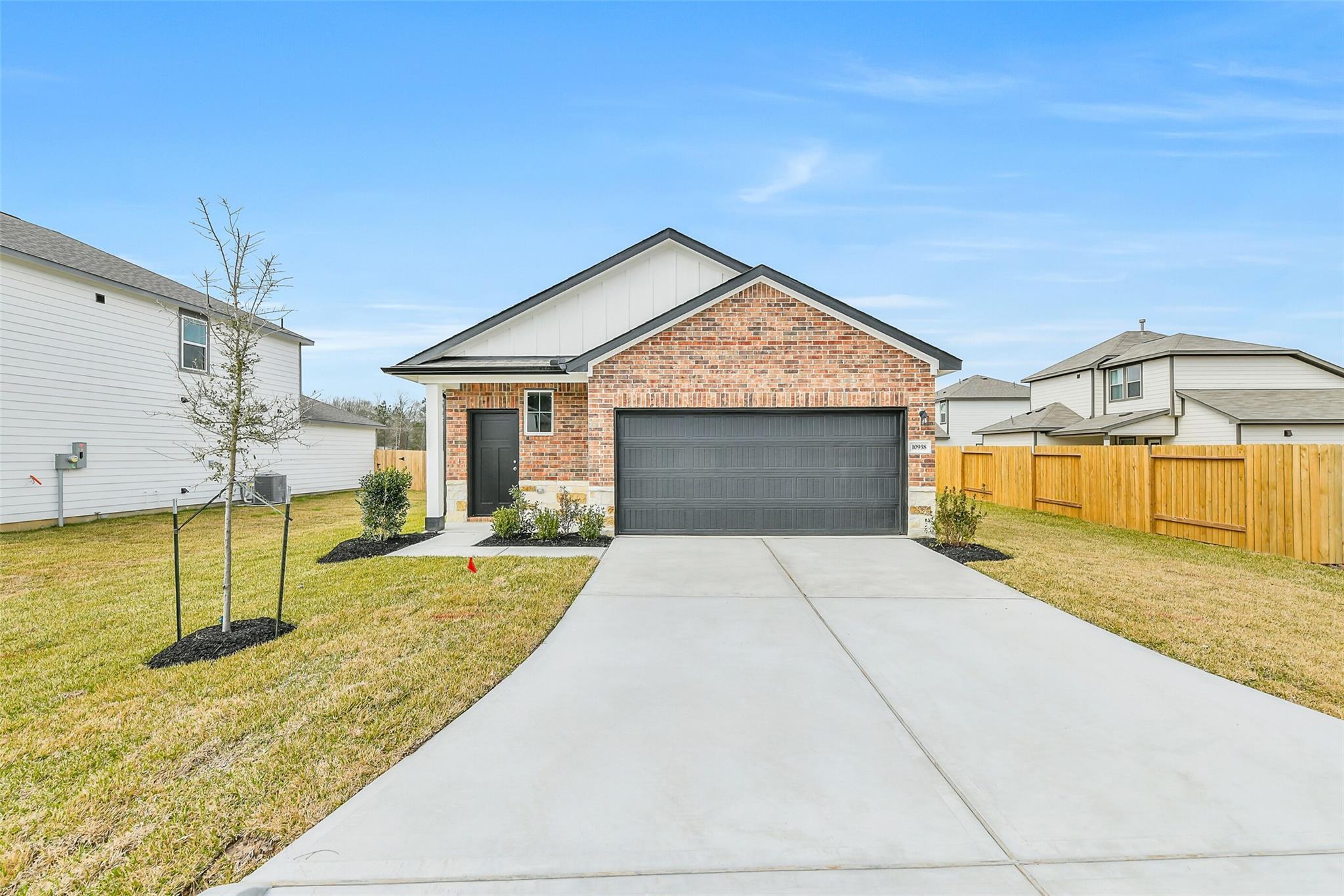 Modern 1-story brick and siding home with 2-car garage, driveway, and landscaped yard in Liberty Estates, Cleveland, Texas - Davidson Homes Frio G