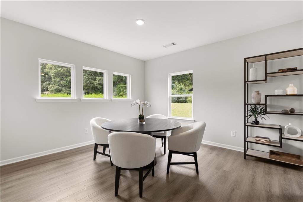 Bright dining area with modern round table and chairs in The Sinclair B floor plan at Cedar Farms in Winder, Georgia.