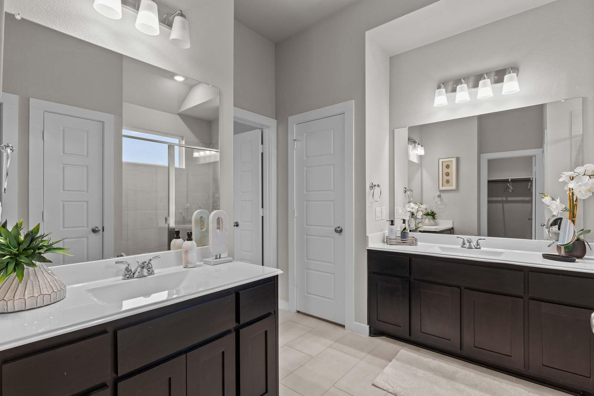 Spacious master bathroom in The Collin A with double sink vanity, dark wood cabinets, and quartz counters