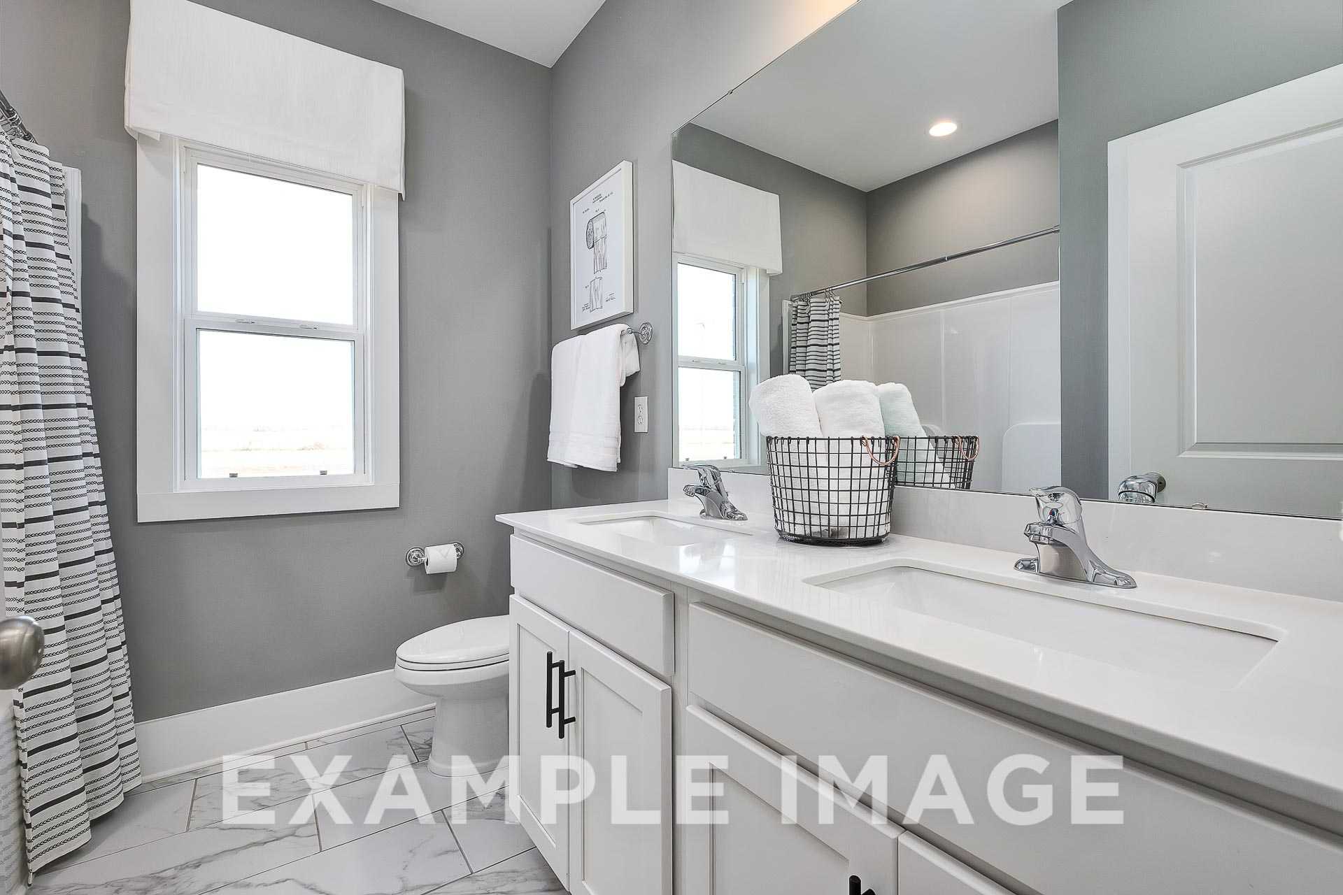 Modern master bathroom in The Everett B with double vanity, gray walls, walk-in shower, and striped curtain