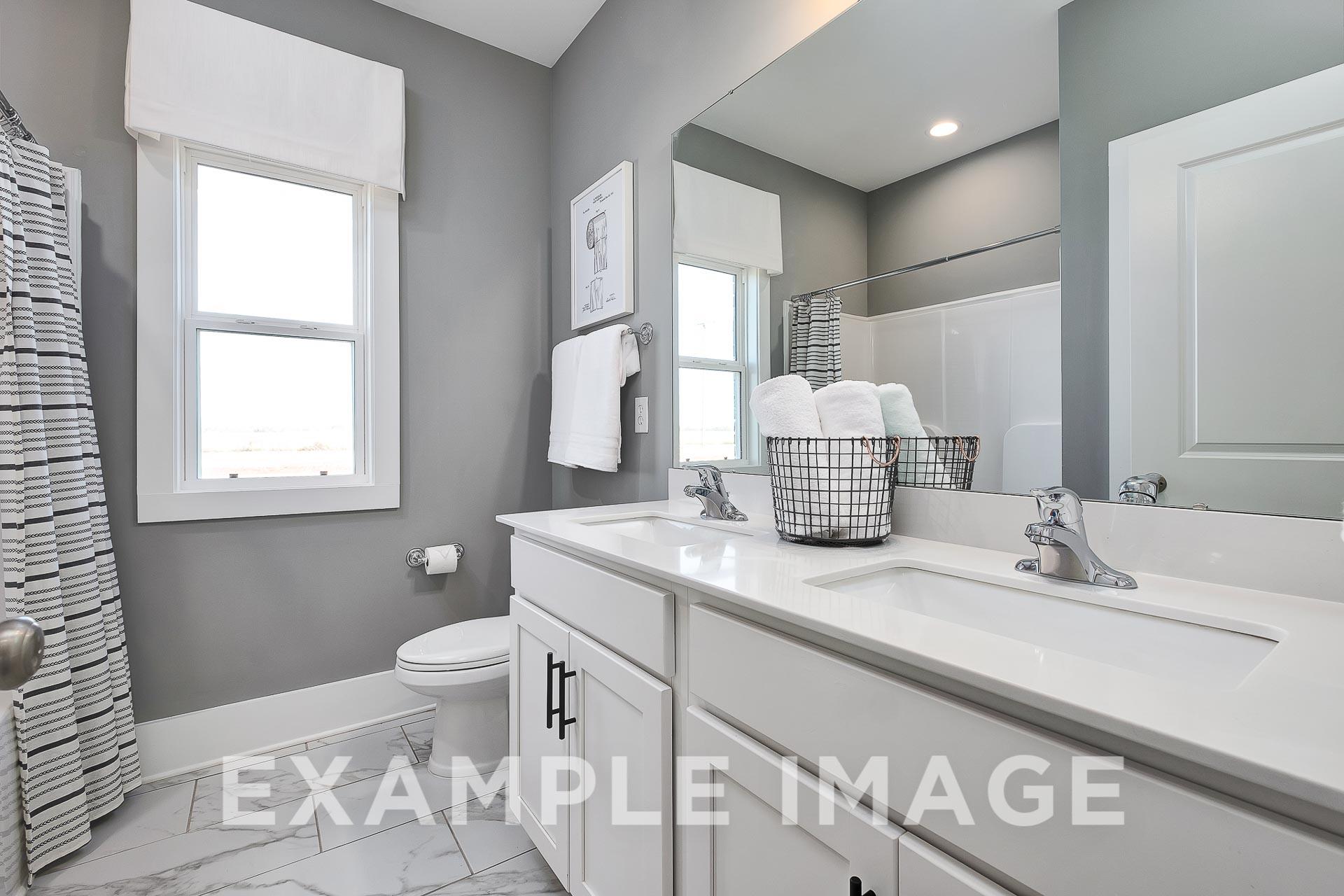Modern master bathroom in The Everett B with double vanity, gray walls, walk-in shower, and striped curtain