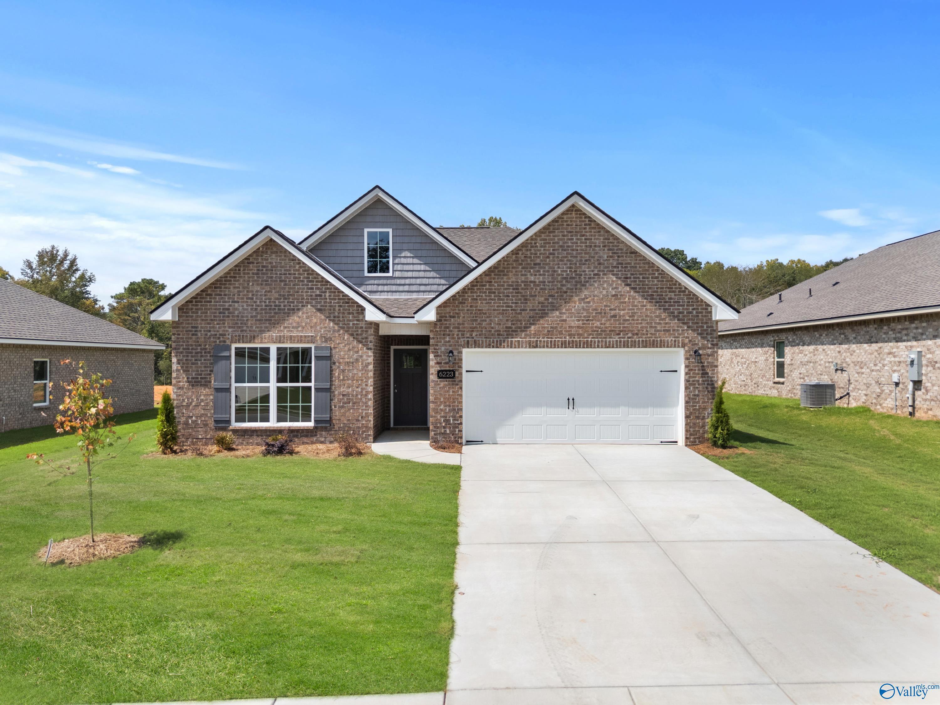 Brick 1-story The Franklin C home by Davidson Homes with 2-car garage, driveway, and green lawn in Spragins Cove, Huntsville, AL
