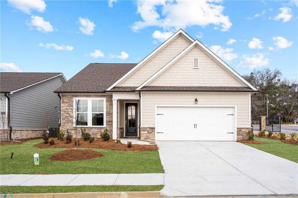 Modern beige single-story home with stone accents, gabled roof, and 2-car garage in Kelly Preserve, Loganville, Georgia - Davidson Homes The Glenwood A