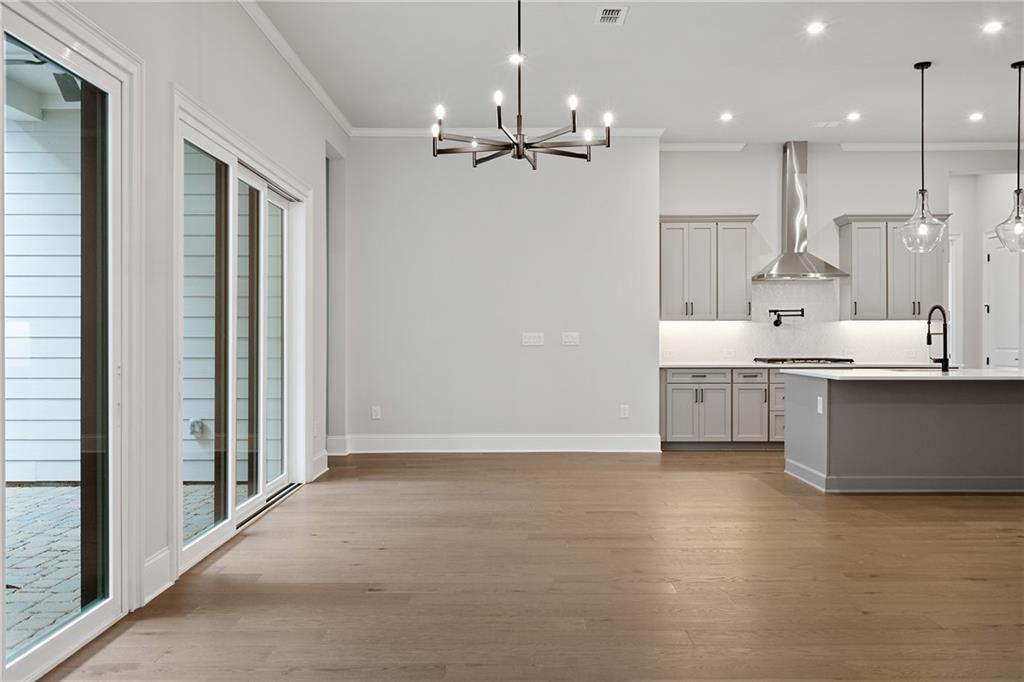 Bright open-concept kitchen and dining with gray island, hardwood floors, sliding doors to patio in Davidson Homes Seaside B, Woodstock GA