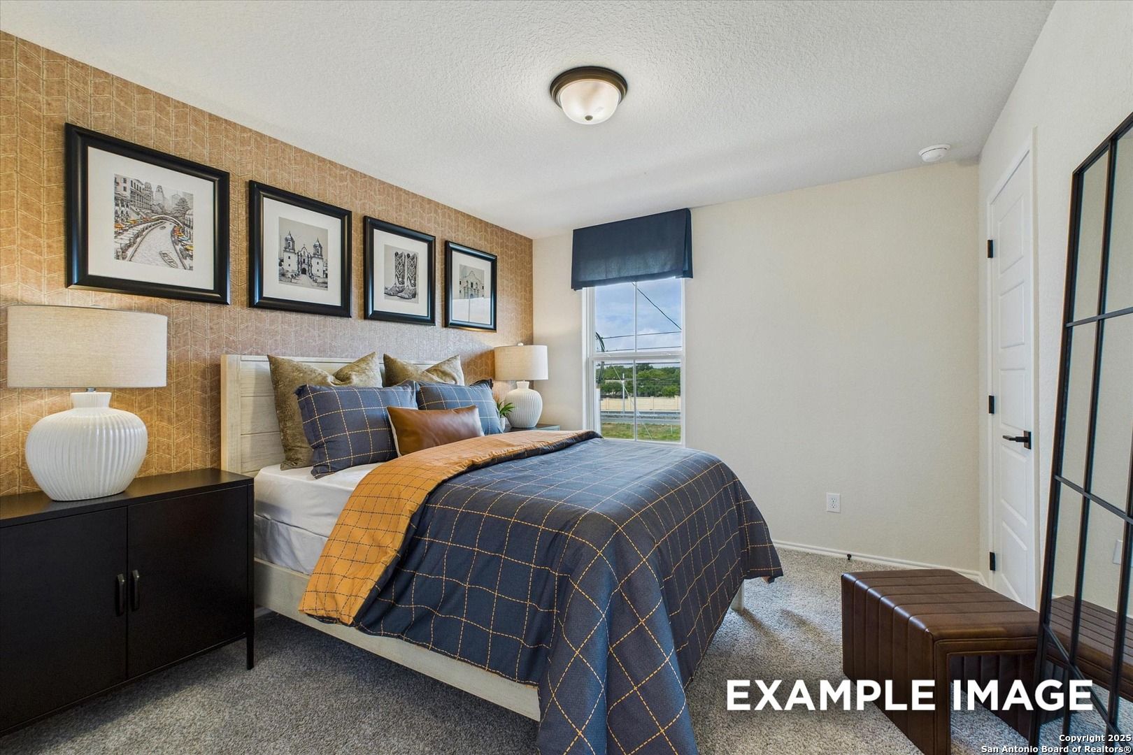 Cozy bedroom with blue plaid bedding, beige walls, framed art, and window view in Davidson Homes The Florence C, San Antonio, Texas