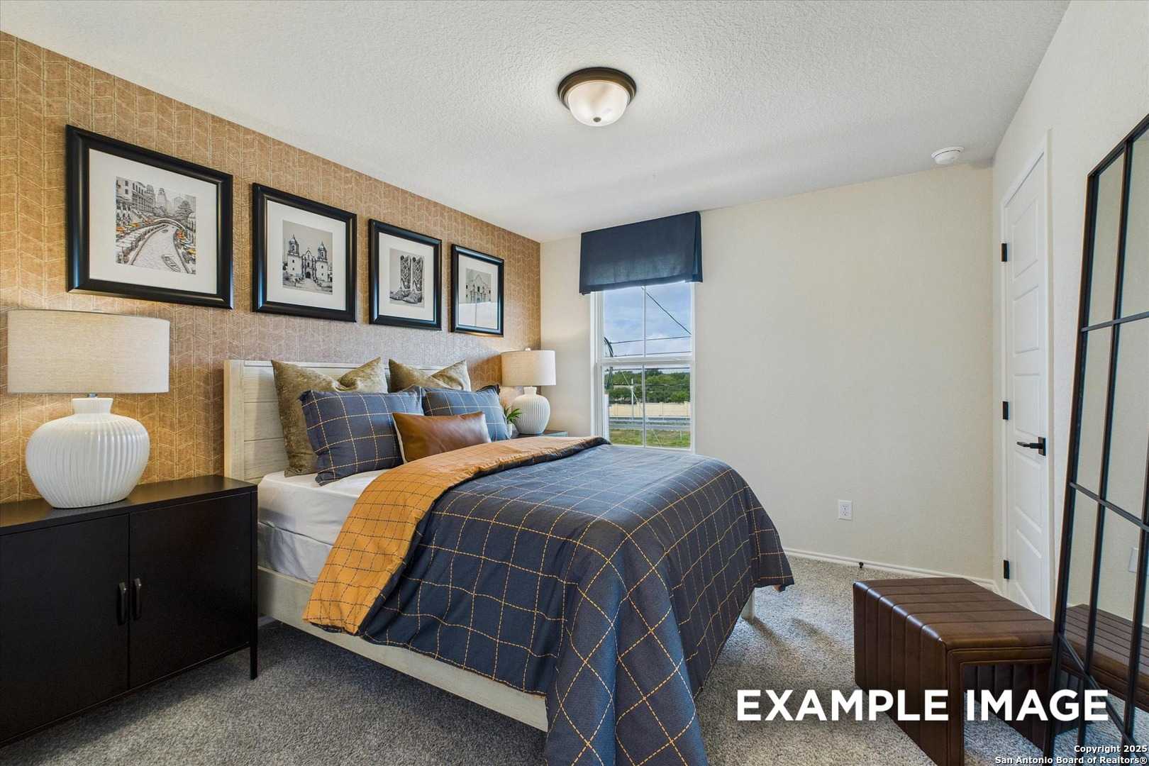 Cozy bedroom with blue plaid bedding, beige walls, framed art, and window view in Davidson Homes The Florence C, San Antonio, Texas