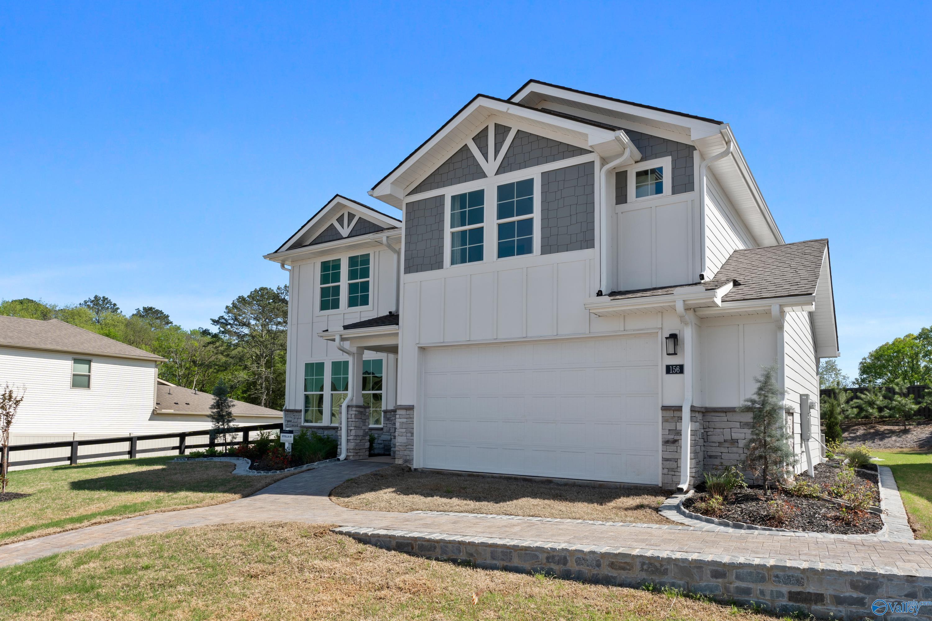 Modern two-story Davidson Homes The Stella with white-gray exterior, 2-car garage, stone accents, and landscaped front yard in Evergreen Mill, Madison, Alabama