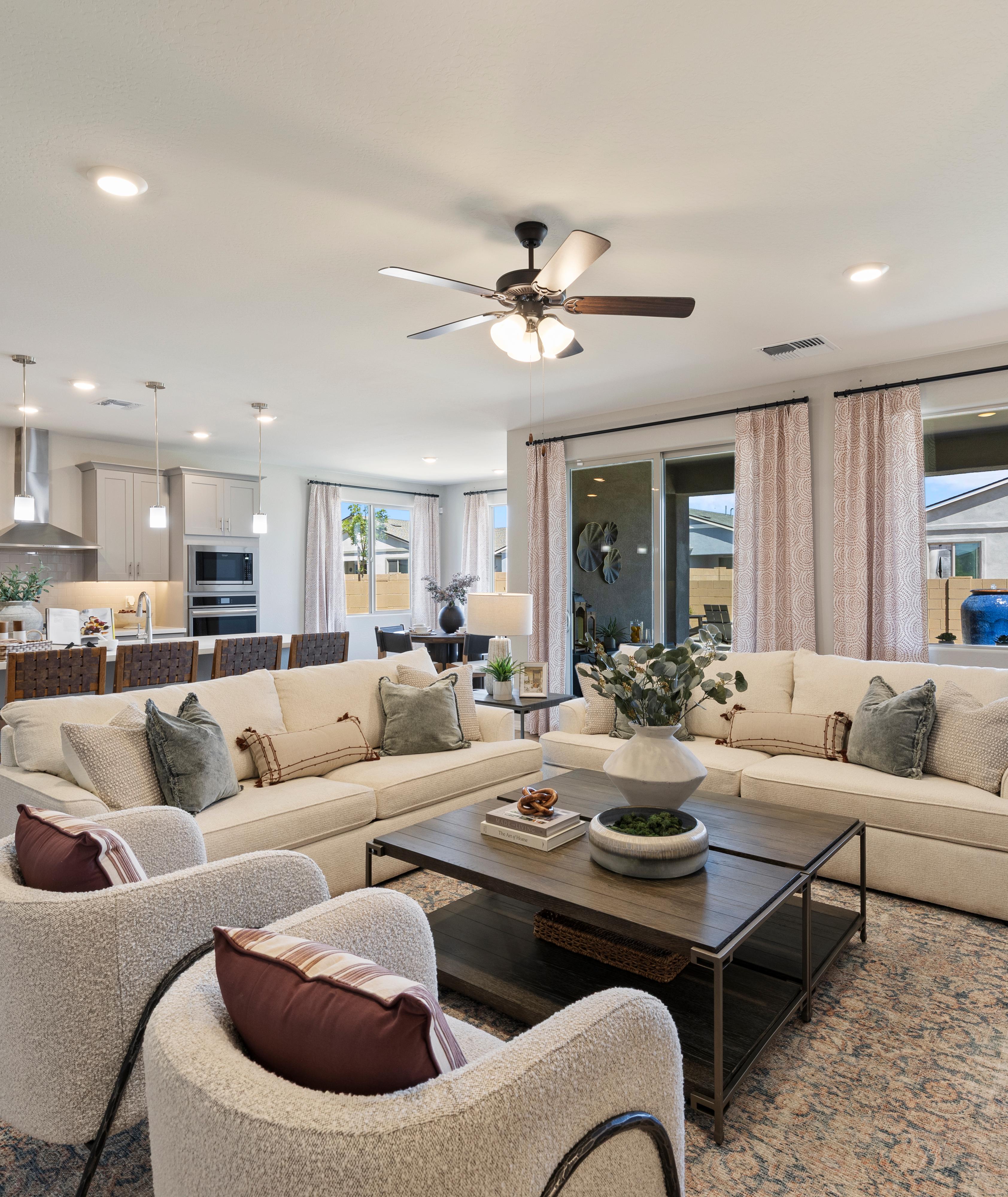 Spacious open-concept living room and kitchen in North Ridge at Pronghorn Ranch, Prescott Valley AZ with beige sofas, hardwood floors, fireplace