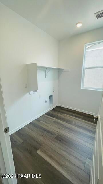 Bright laundry room with wood-look flooring and shelving in The Summit A floor plan at Westwood, Prescott, Arizona.