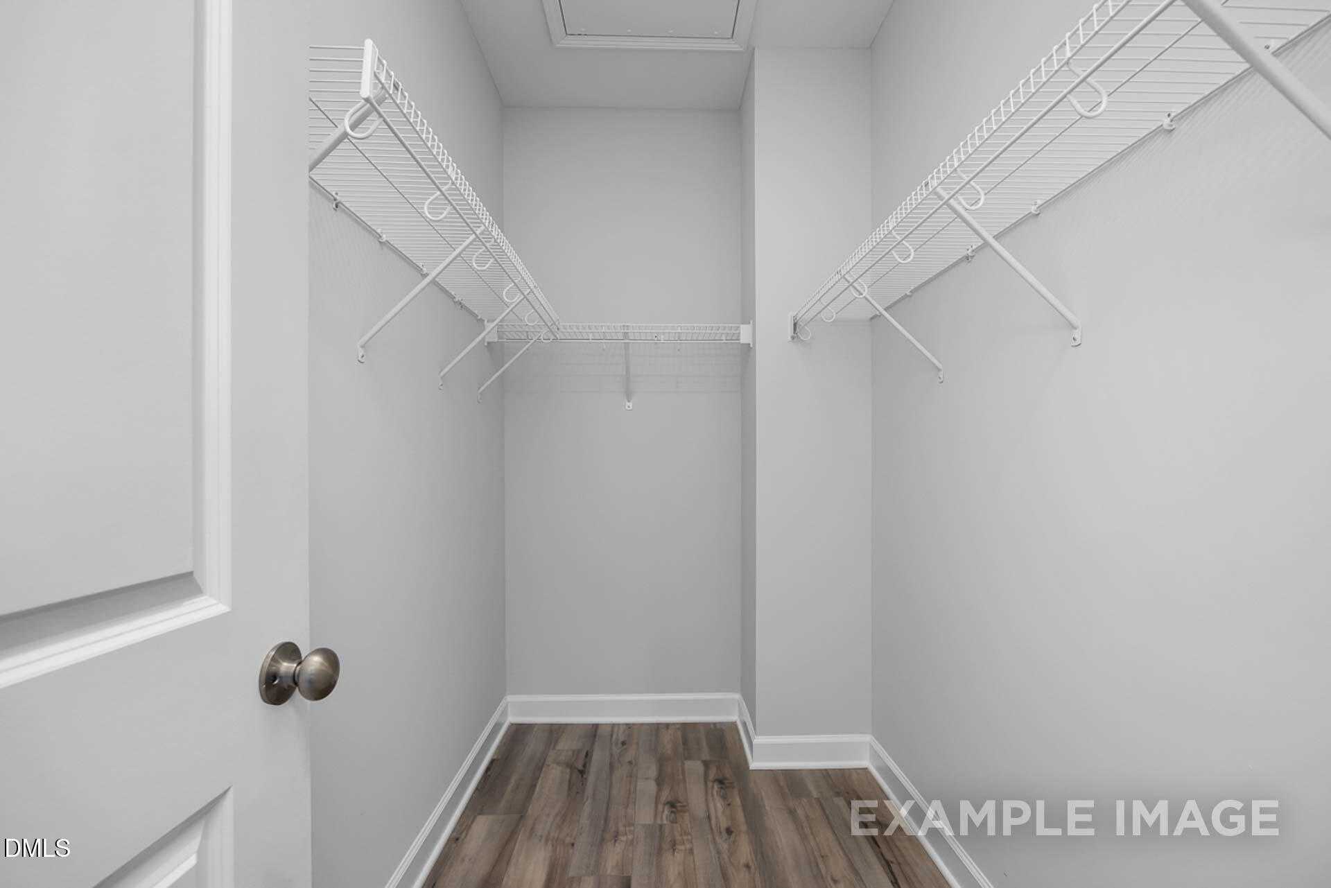 Spacious walk-in closet with white wire shelving and light wood floors in Davidson Homes The Carter C, Lillington, NC