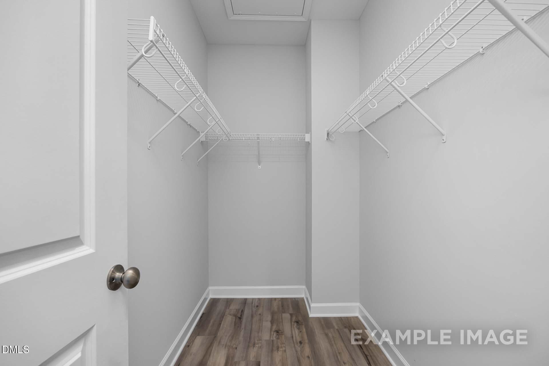 Spacious walk-in closet with white wire shelving and hardwood floors in Davidson Homes The Carter C, Lillington, NC