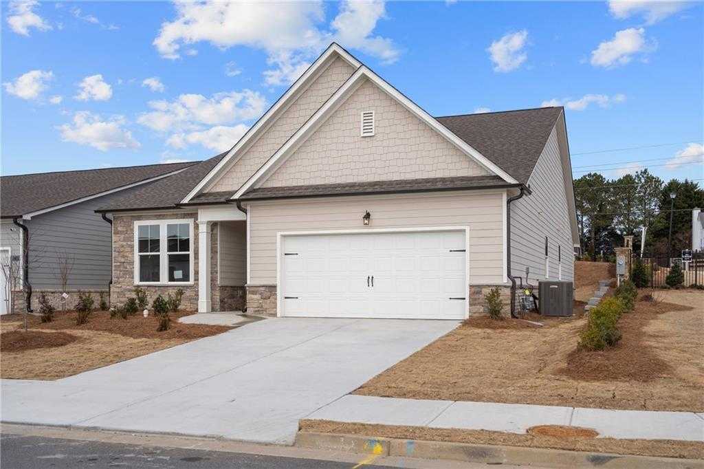 Modern beige single-story home with 2-car garage, driveway, and landscaping in Kelly Preserve, Loganville, Georgia by Davidson Homes