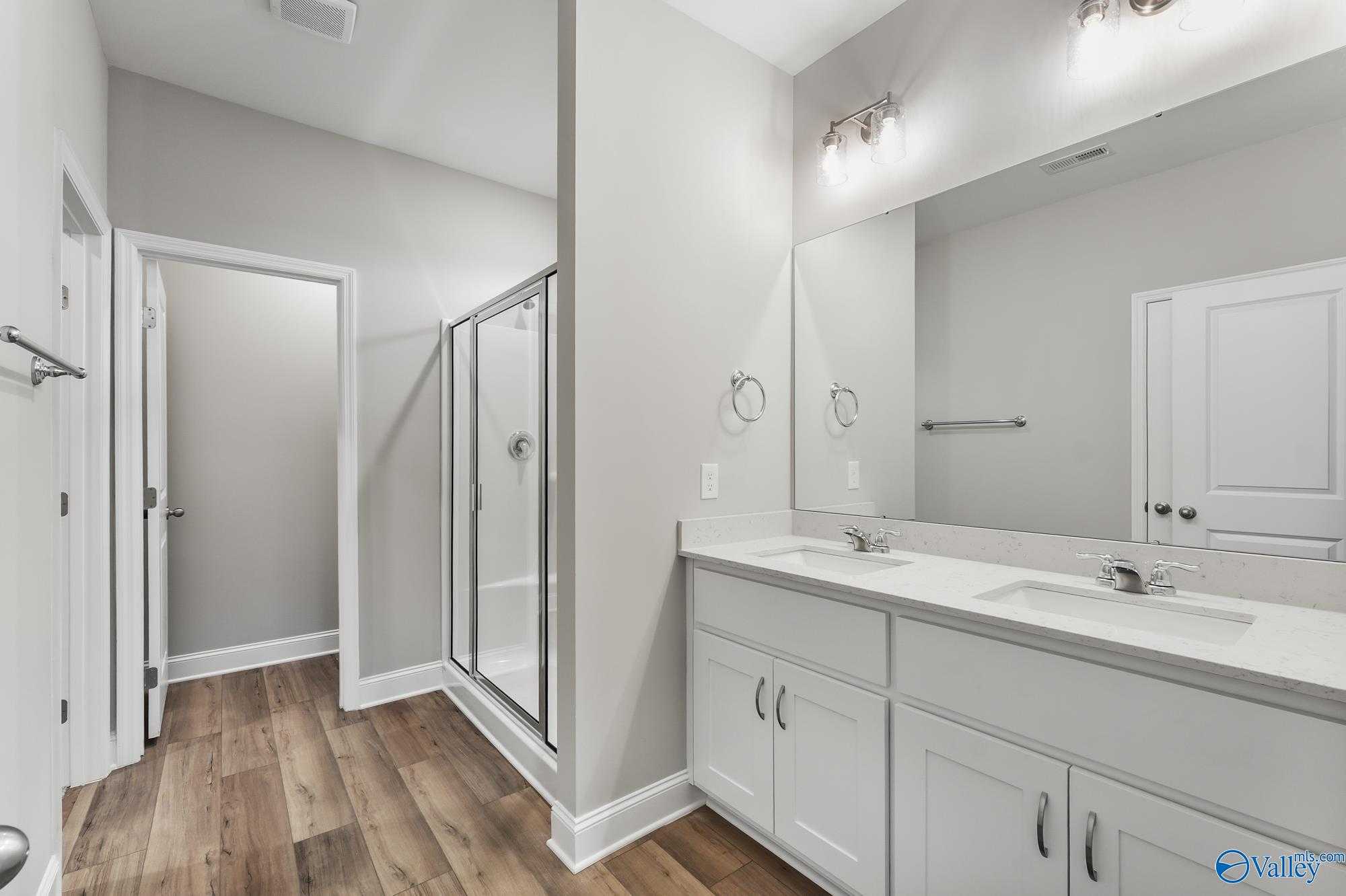 Modern master bathroom with double vanity, frameless glass shower in Davidson Homes The Daphne D, Athens, Alabama
