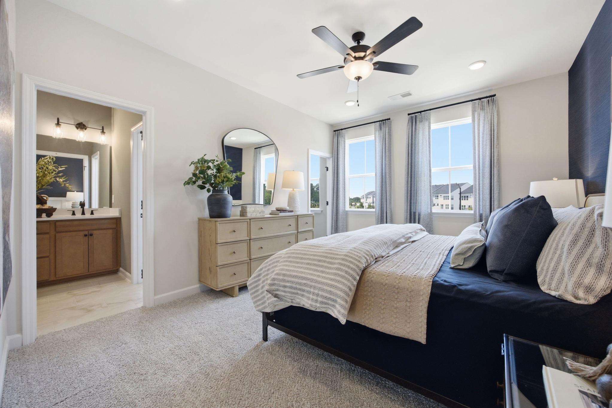 Spacious primary bedroom at Forestville Yard in Knightdale, NC by Davidson Homes featuring plush carpet and ensuite bath.