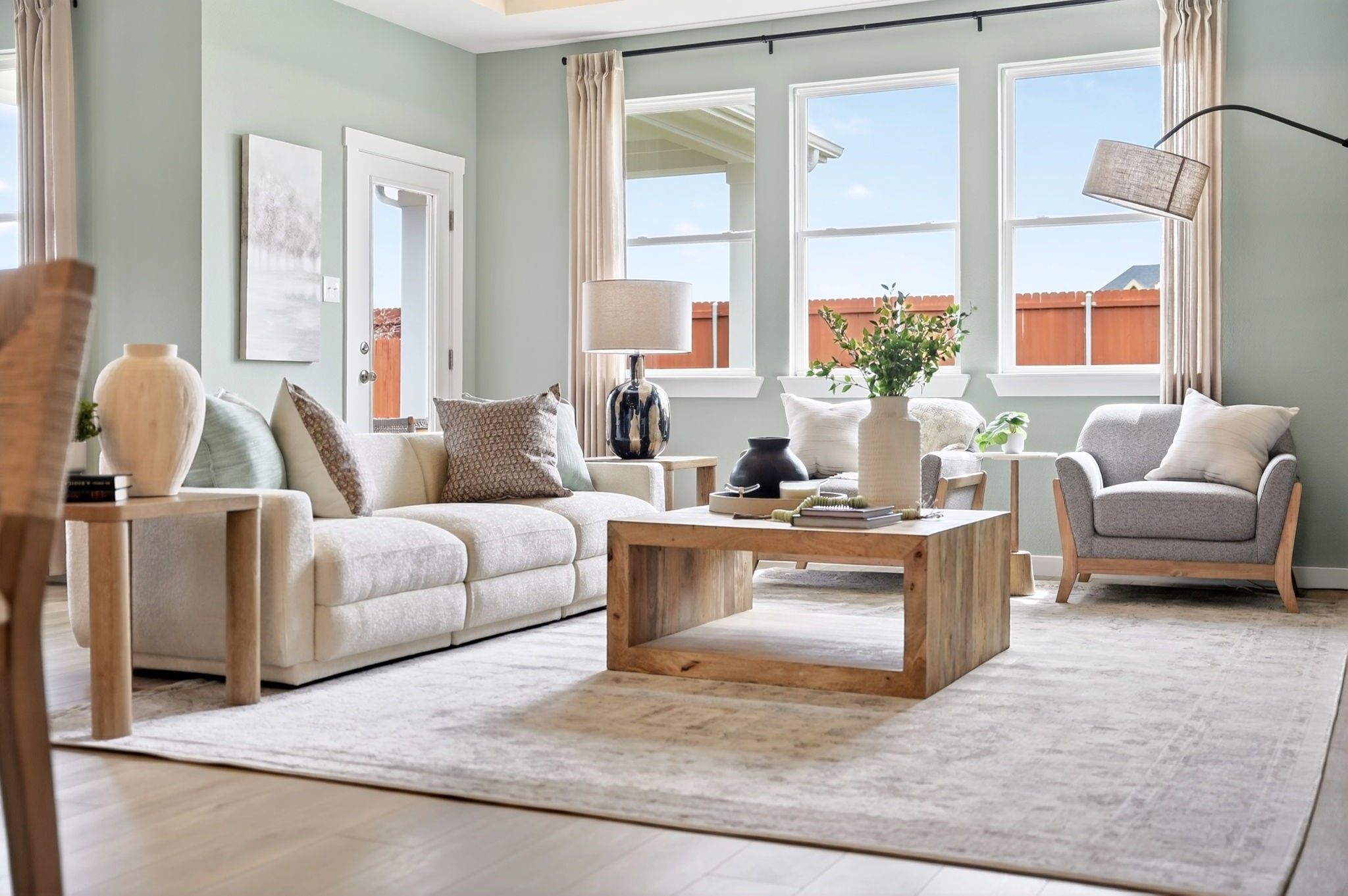 Bright, open-concept living room with modern decor in The Laurel M floor plan at Parks at Foster Crossing in Anna, Texas.
