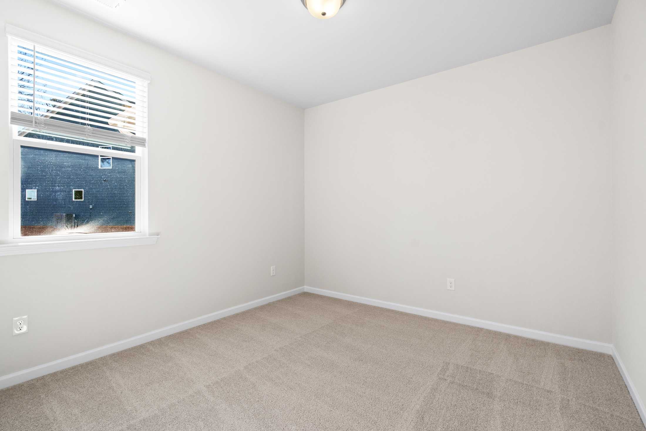 Spacious secondary bedroom in The Glenwood A featuring beige carpet, white walls, window blinds, and ceiling light