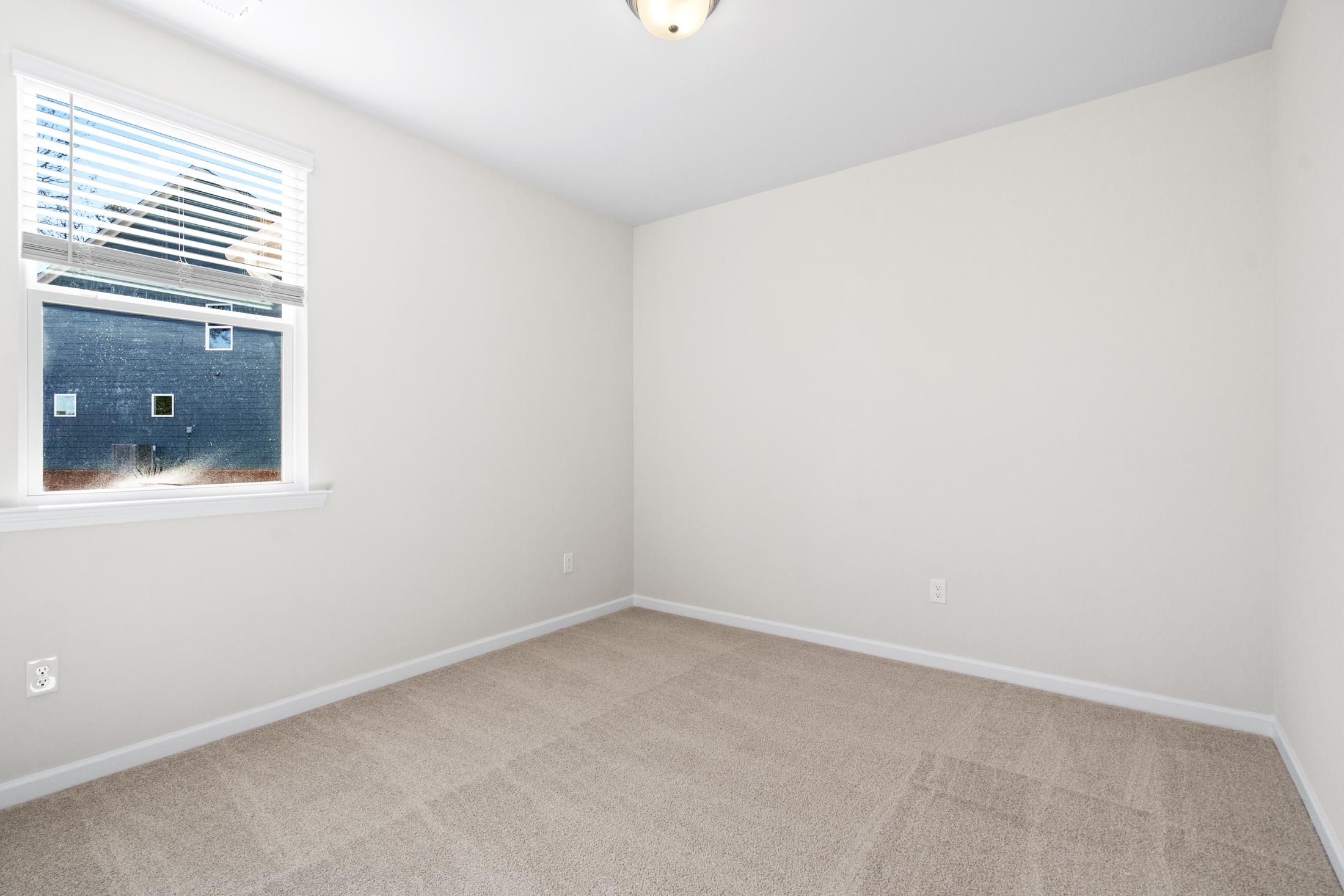 Spacious secondary bedroom in The Glenwood A featuring beige carpet, white walls, window blinds, and ceiling light
