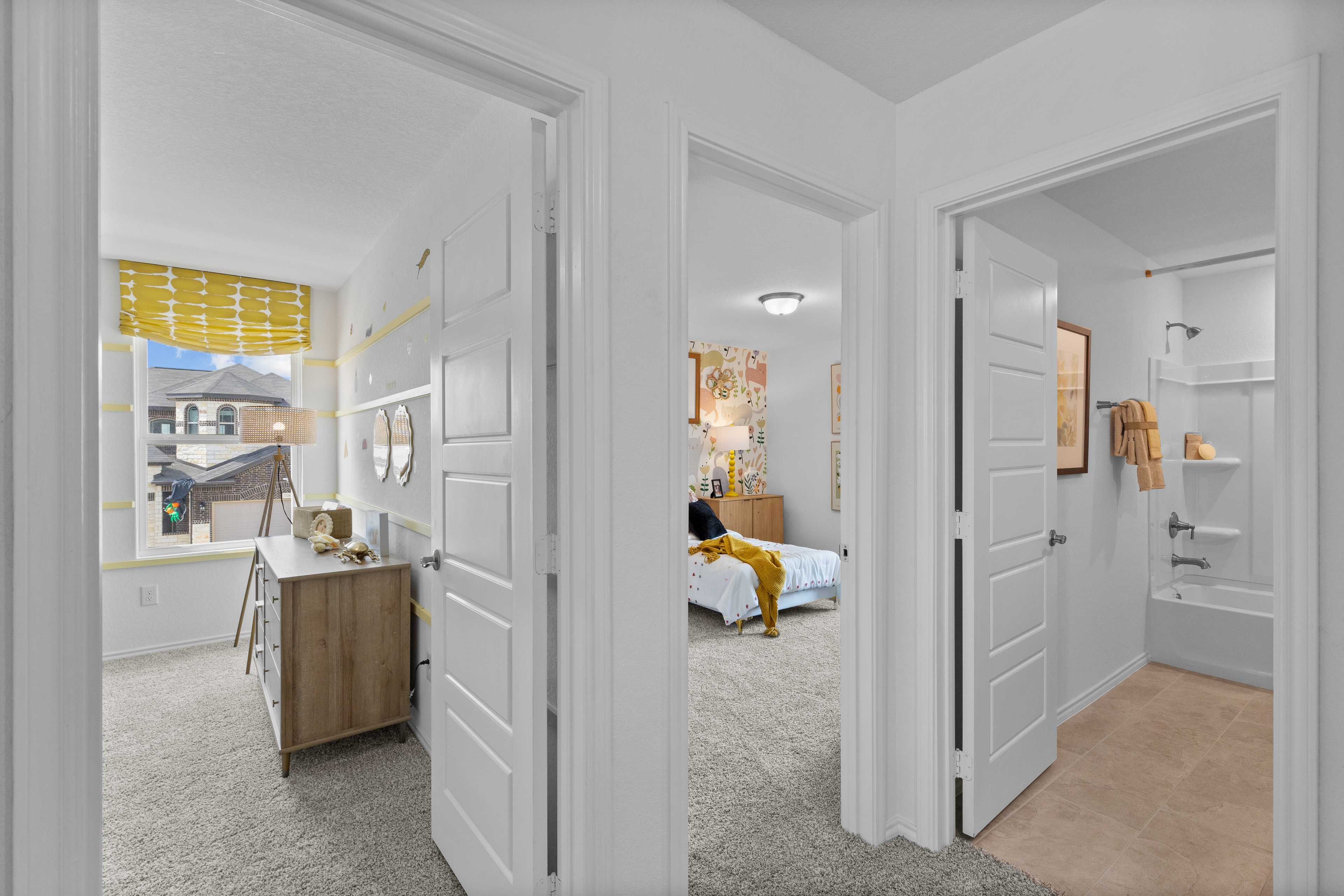 Spacious bedroom suite at Horizon Pointe in Converse Texas with en-suite bathroom, yellow bedding, and modern tub shower