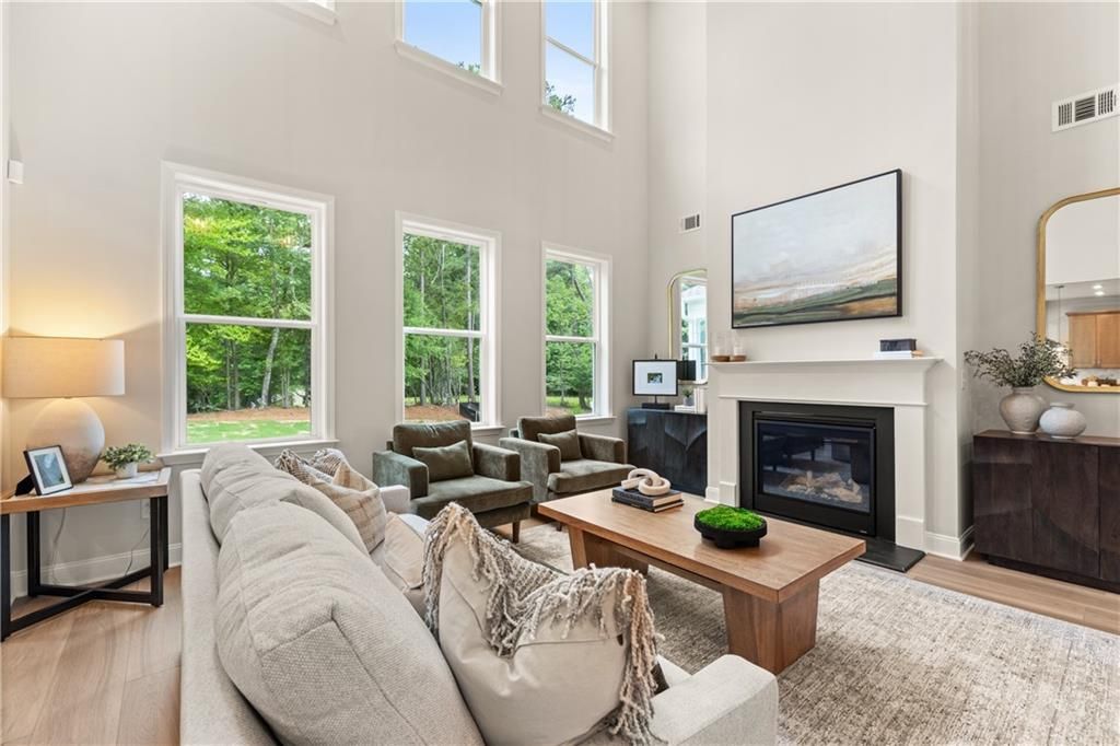 Two-story great room with fireplace, tall windows, and cozy seating in Davidson Homes Danbury E plan, Buford, Georgia