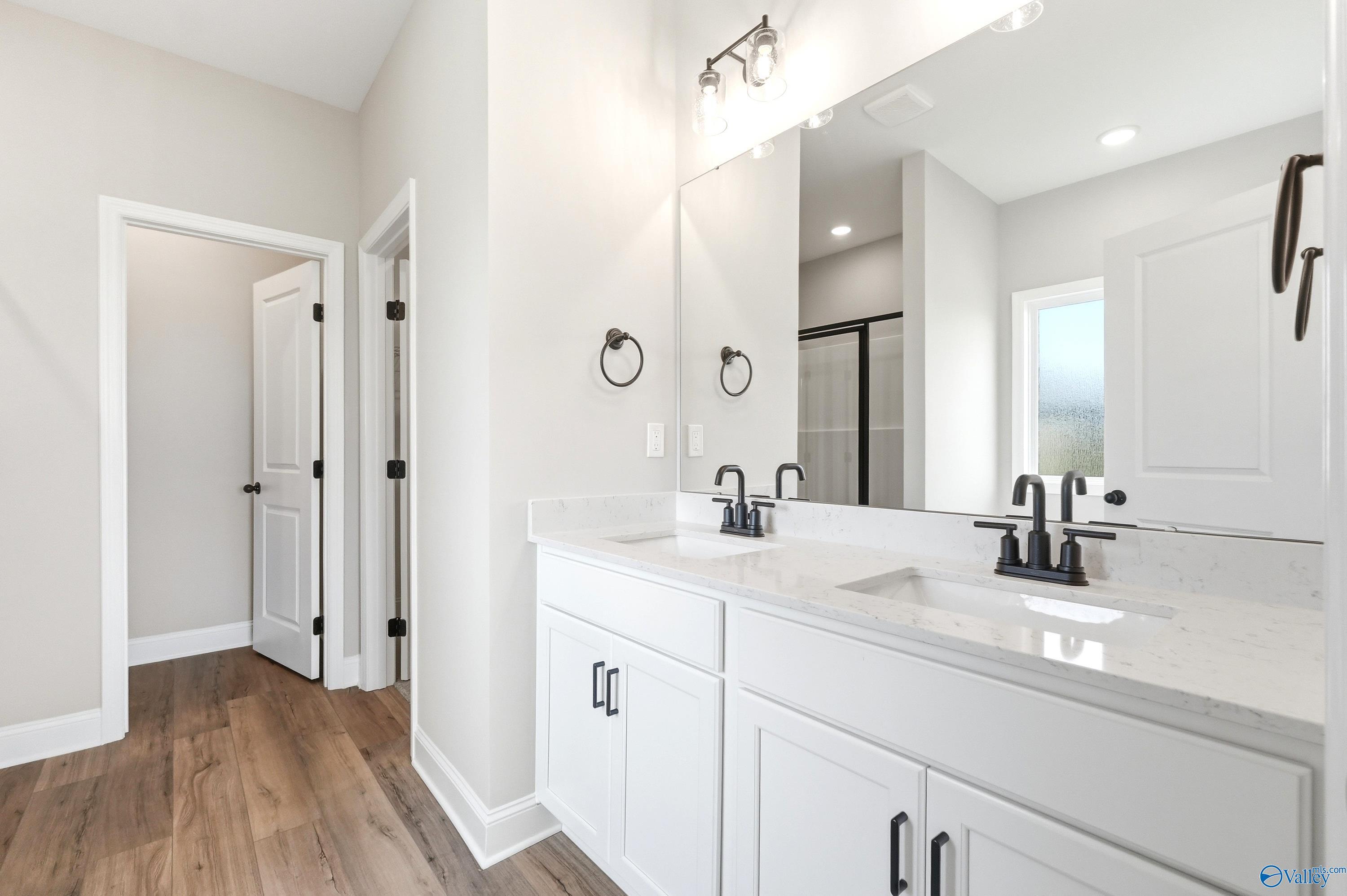 Double vanity with quartz countertops and matte black fixtures in a Daphne D floor plan home in Creekside, Harvest, AL.